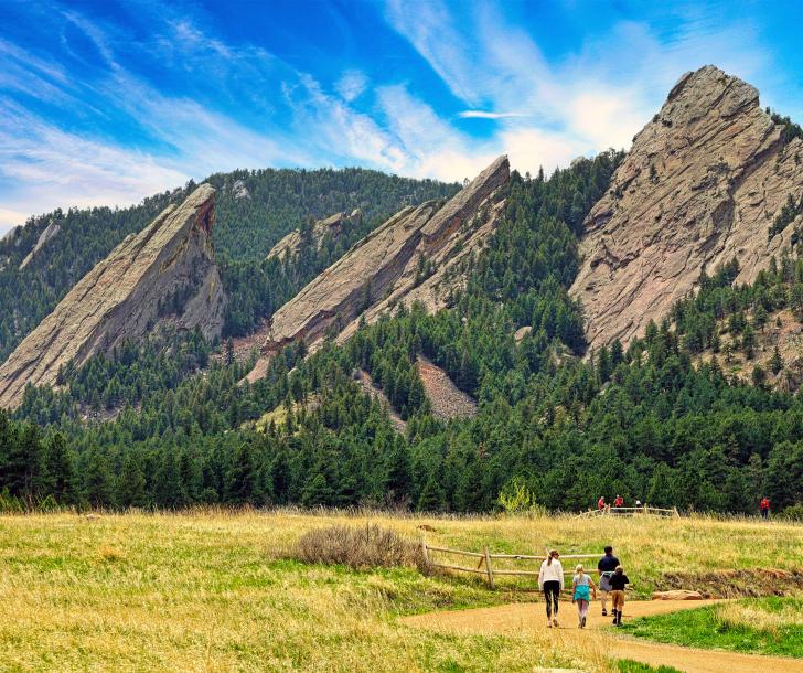 Chautauqua hike with view of flatirons and family walking up