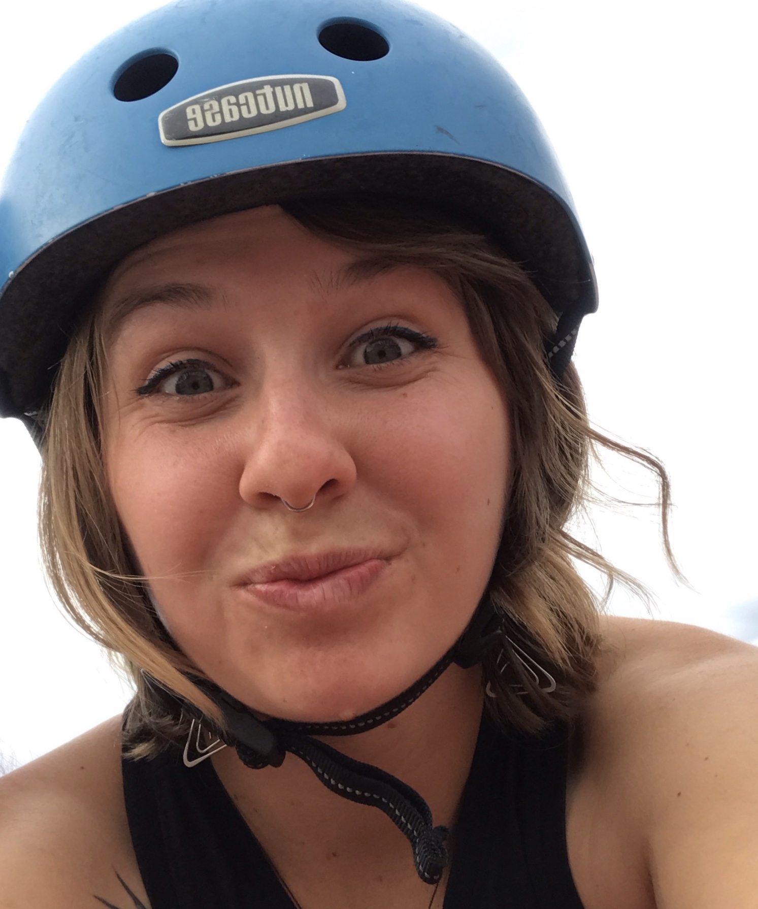 Maddie makes a silly face while wearing a blue helmet.