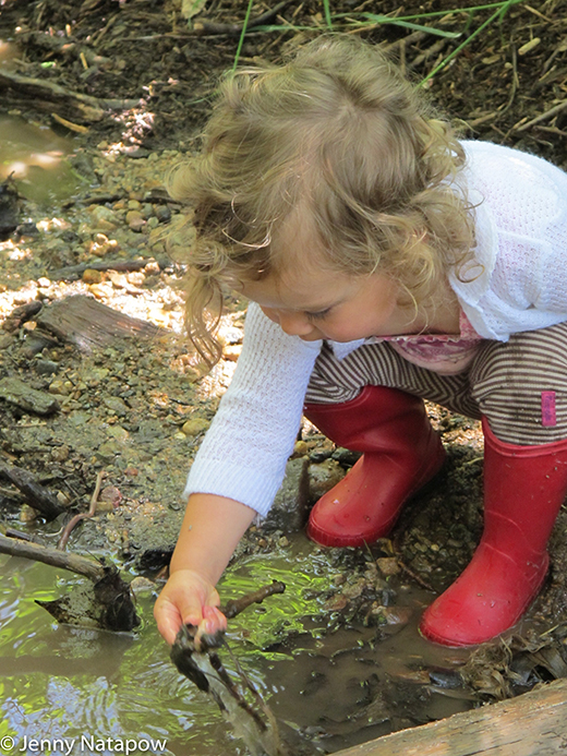 Child exploring in the mud