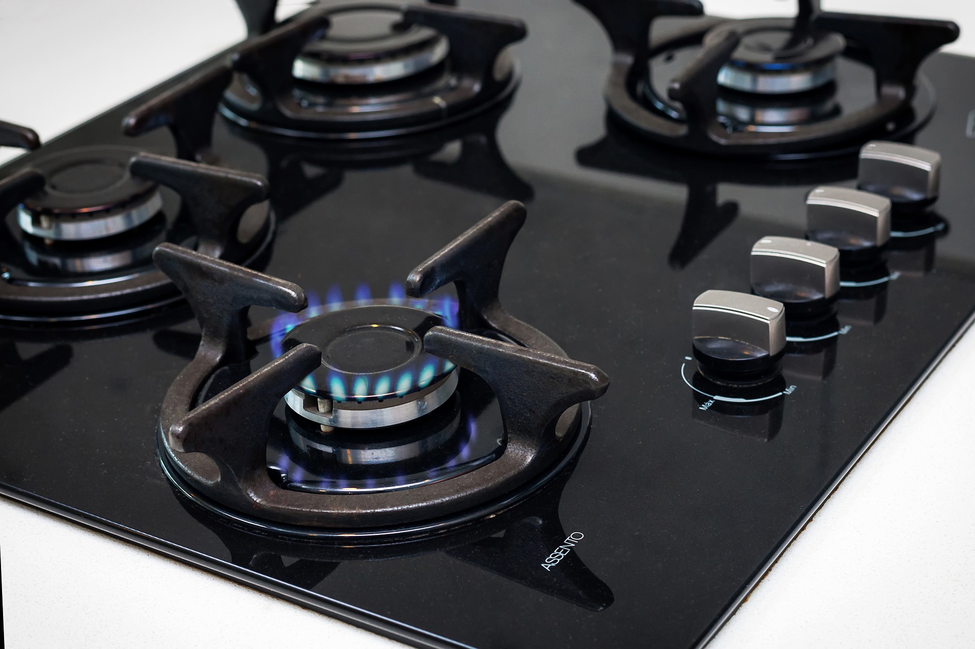 Image of a gas stove with a burner on.