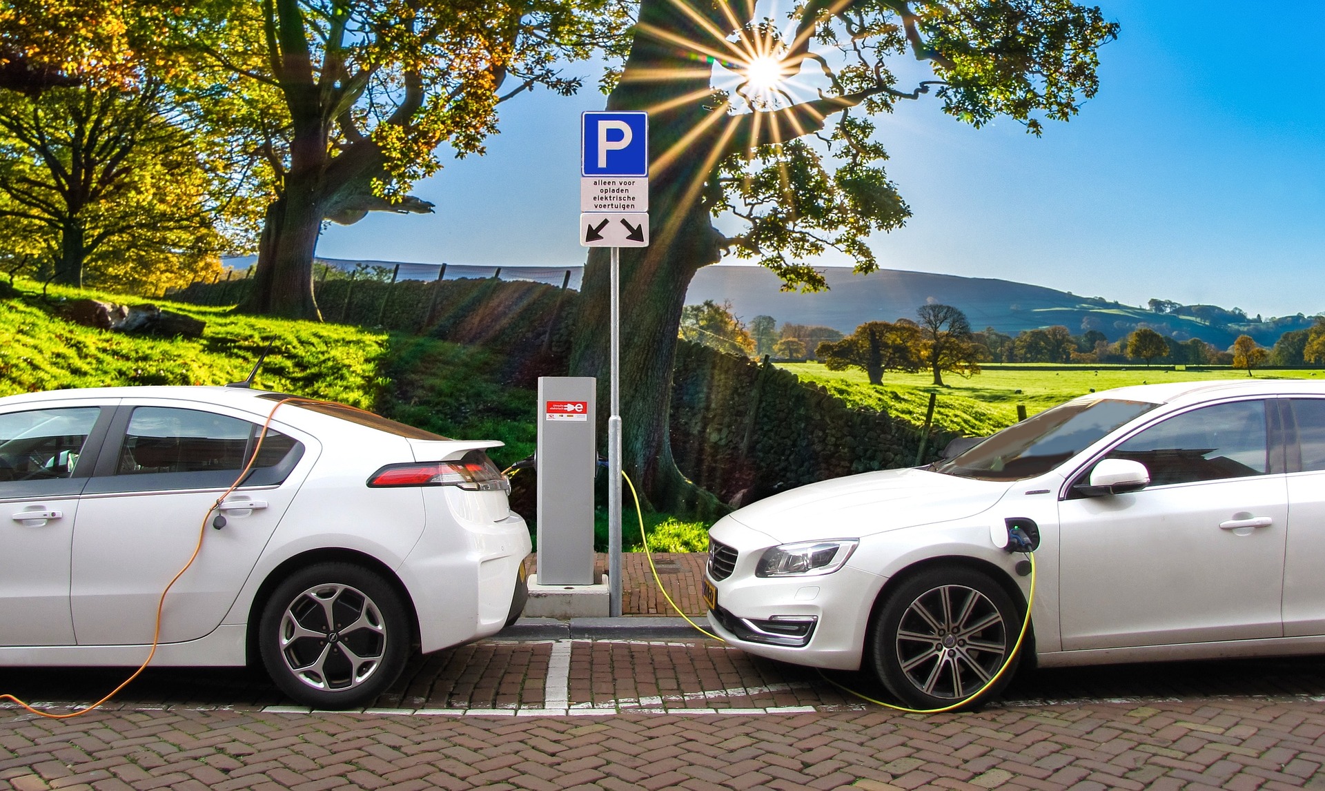 Photo of two electric cars plugged into a charging station