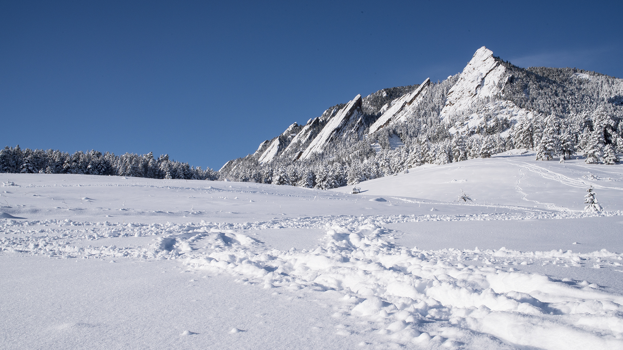 Photo of the snow-covered Boulder Flatirons after a winter snow storm.