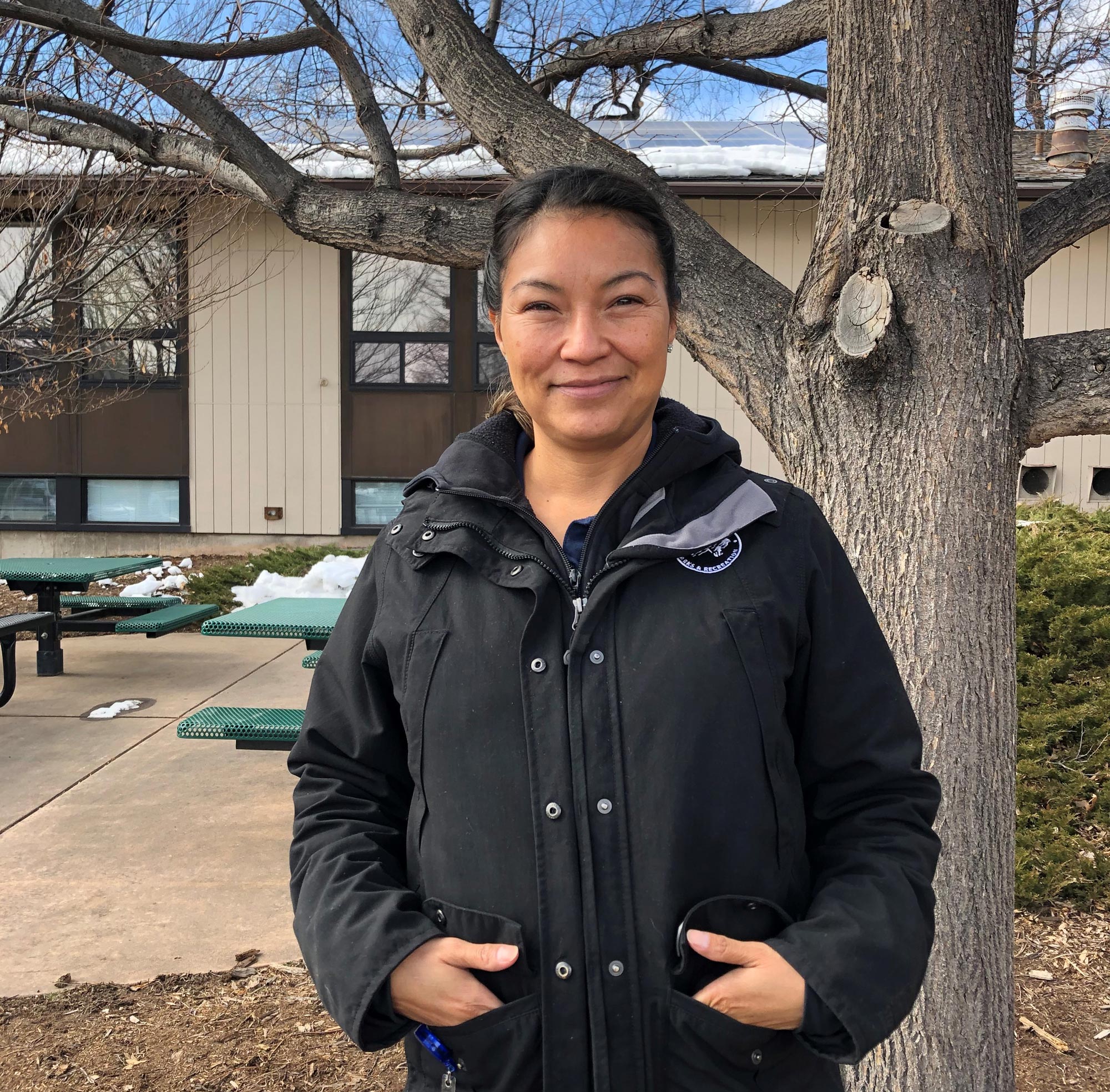 Corina smiles and stands outside the Iris building.