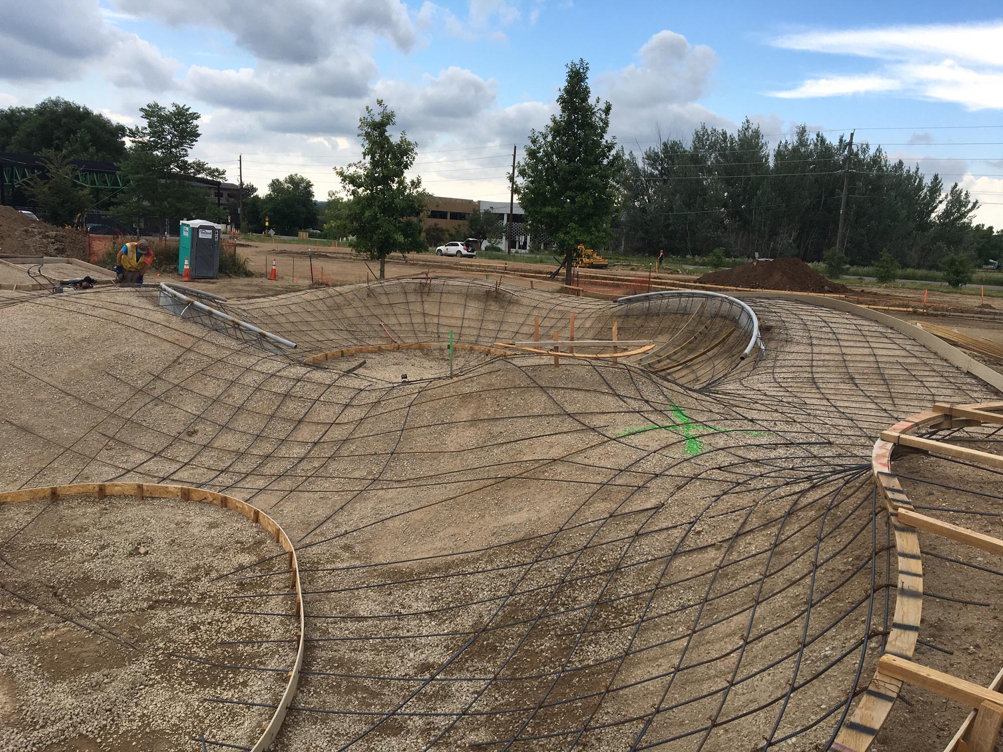 Wires crisscross over molded dirt, where concrete will soon be poured for the skate area at Valmont City Park.