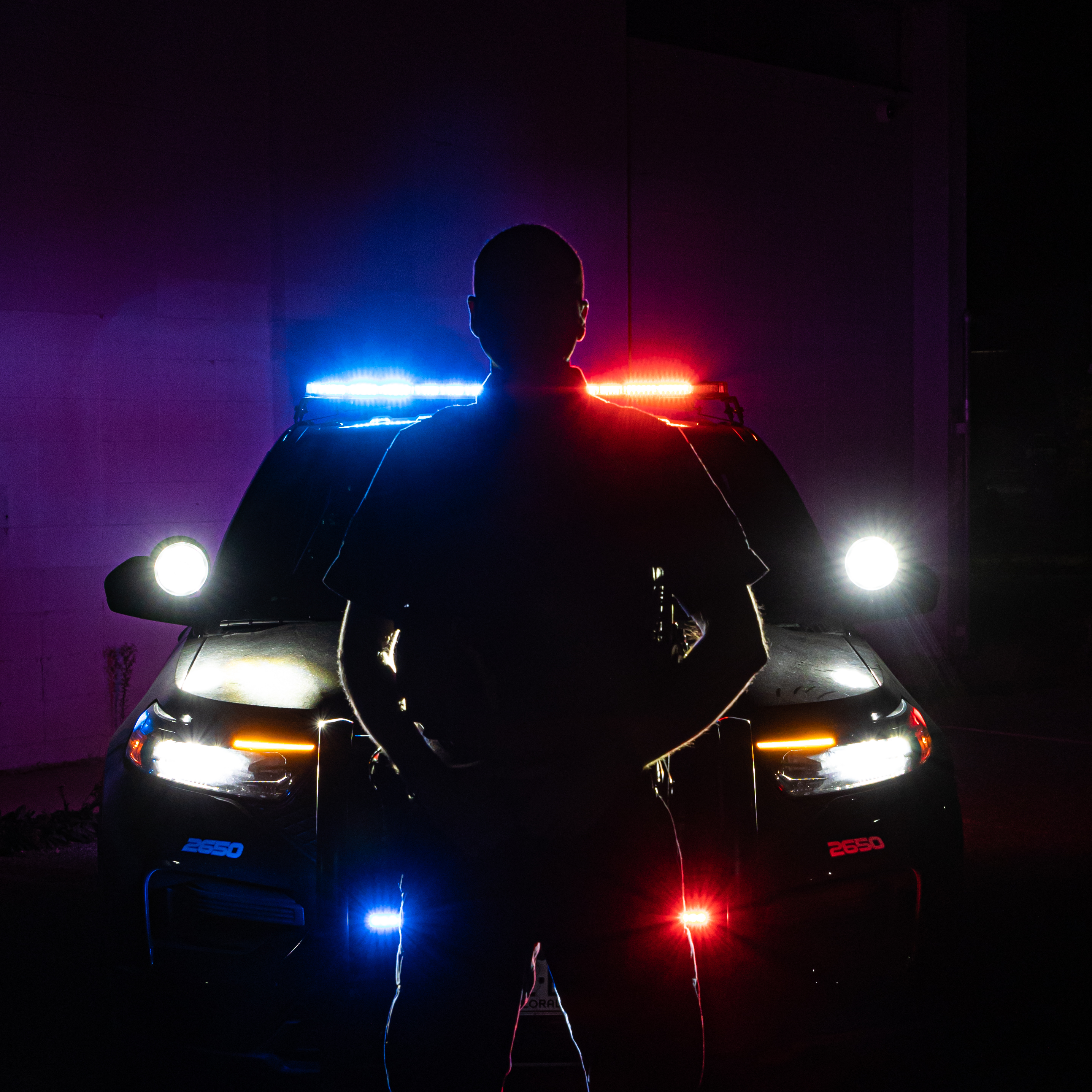 Silhouetted Boulder PD officer posing in front of vehicle 
