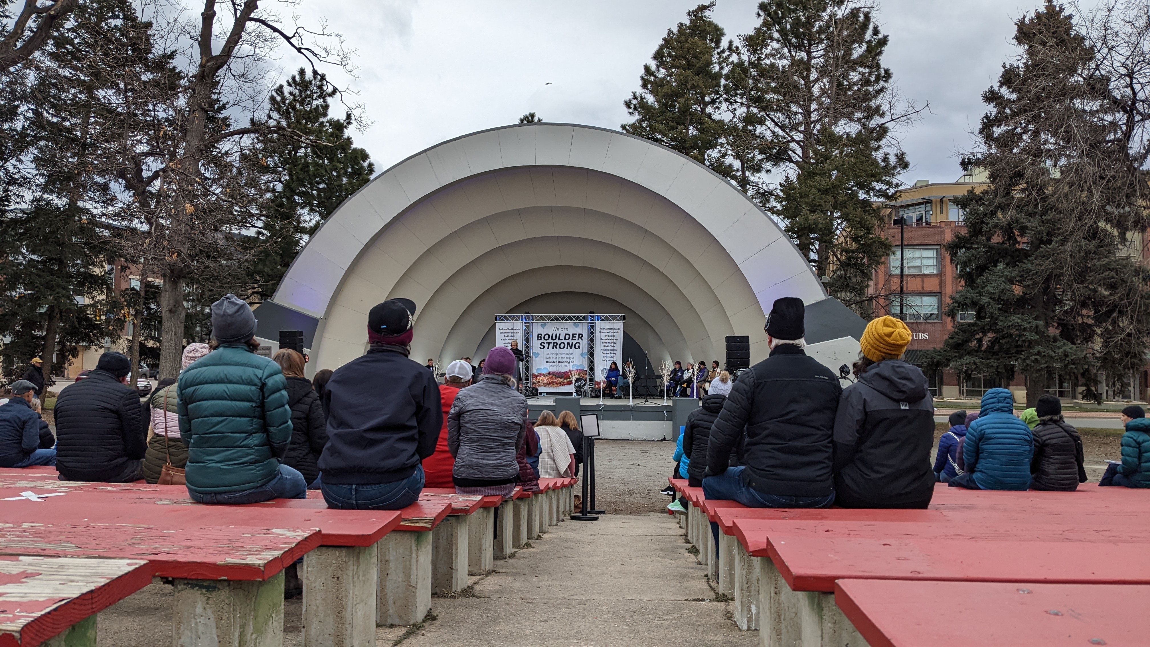 People sitting at bandshell for the March 22 Communitywide Day of Remembrance Gathering