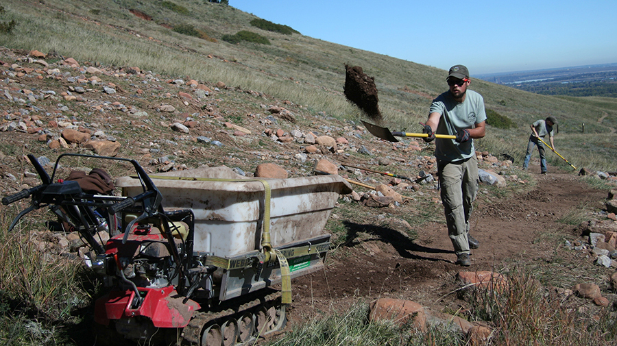 Un miembro del personal de OSMP trabaja para completar las reparaciones temporales de senderos a lo largo de un sendero dañado por inundaciones.