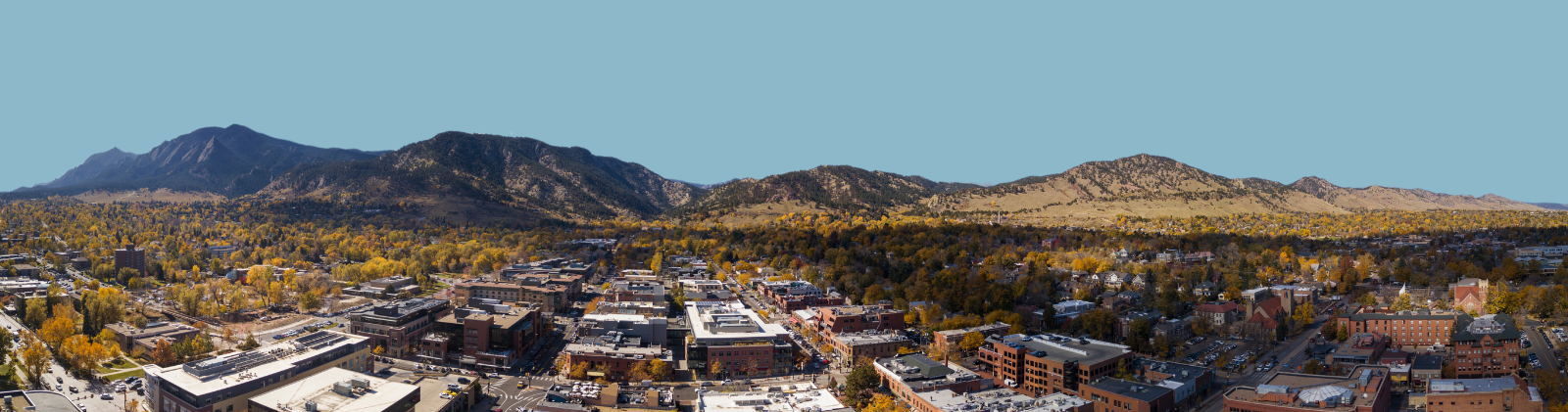 Aerial view of Boulder buildings with Flatirons in the distance