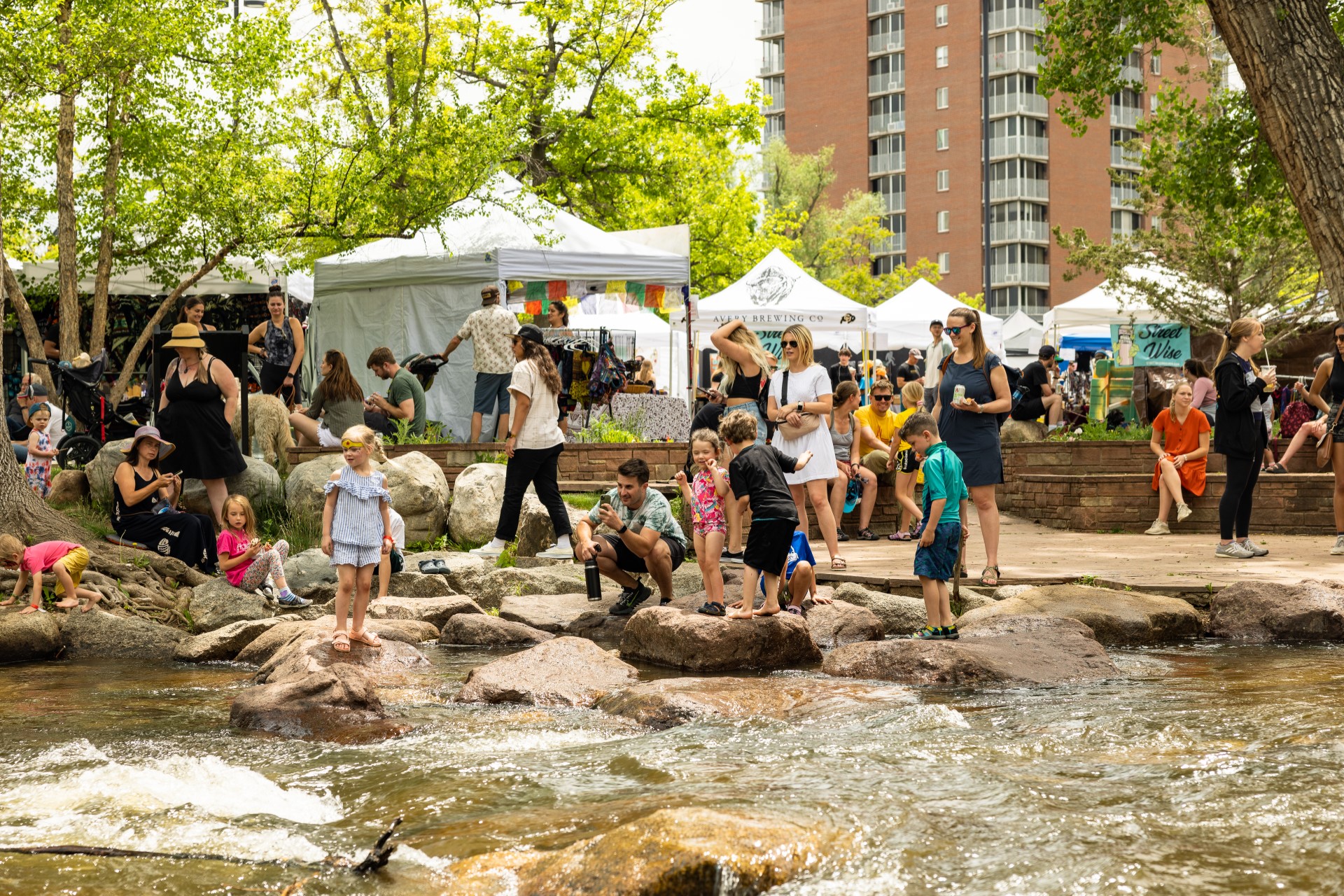 people hanging out by the creek during boulder creek fest facing south