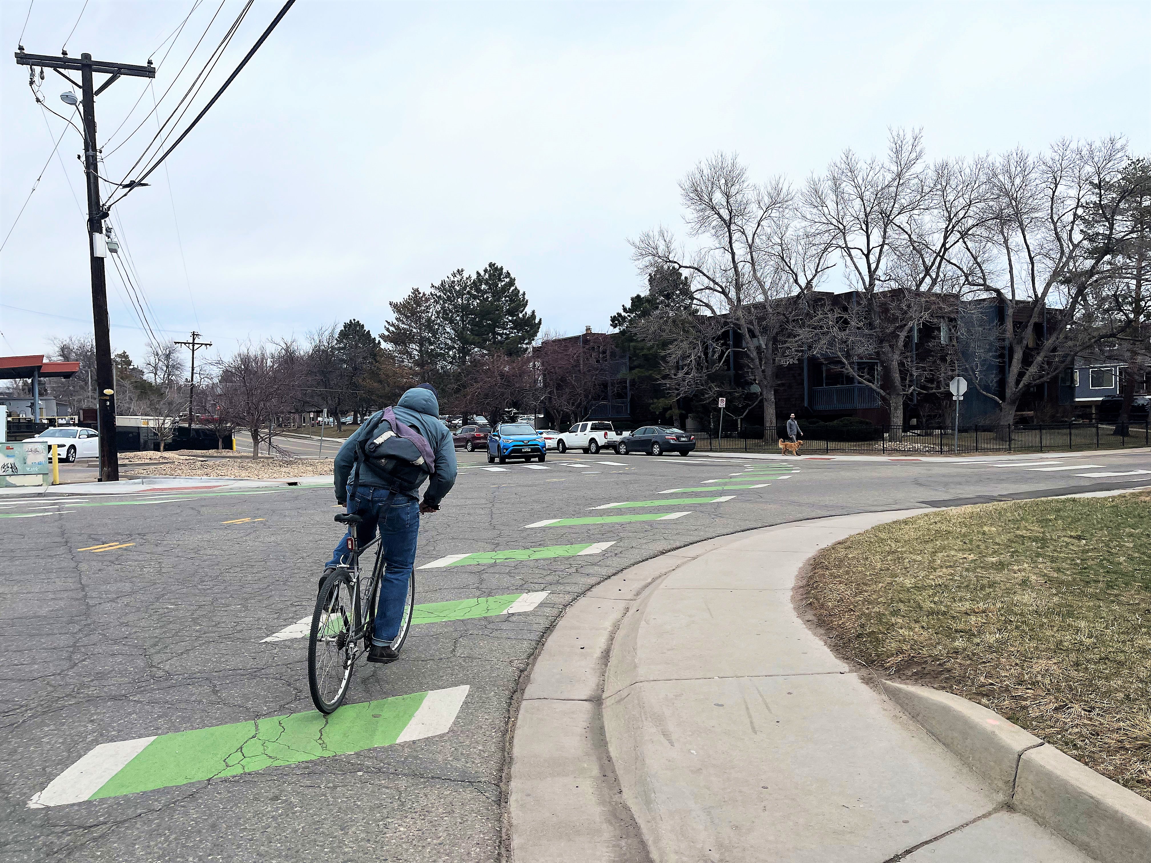Persona en bicicleta por carril bici verde rayado