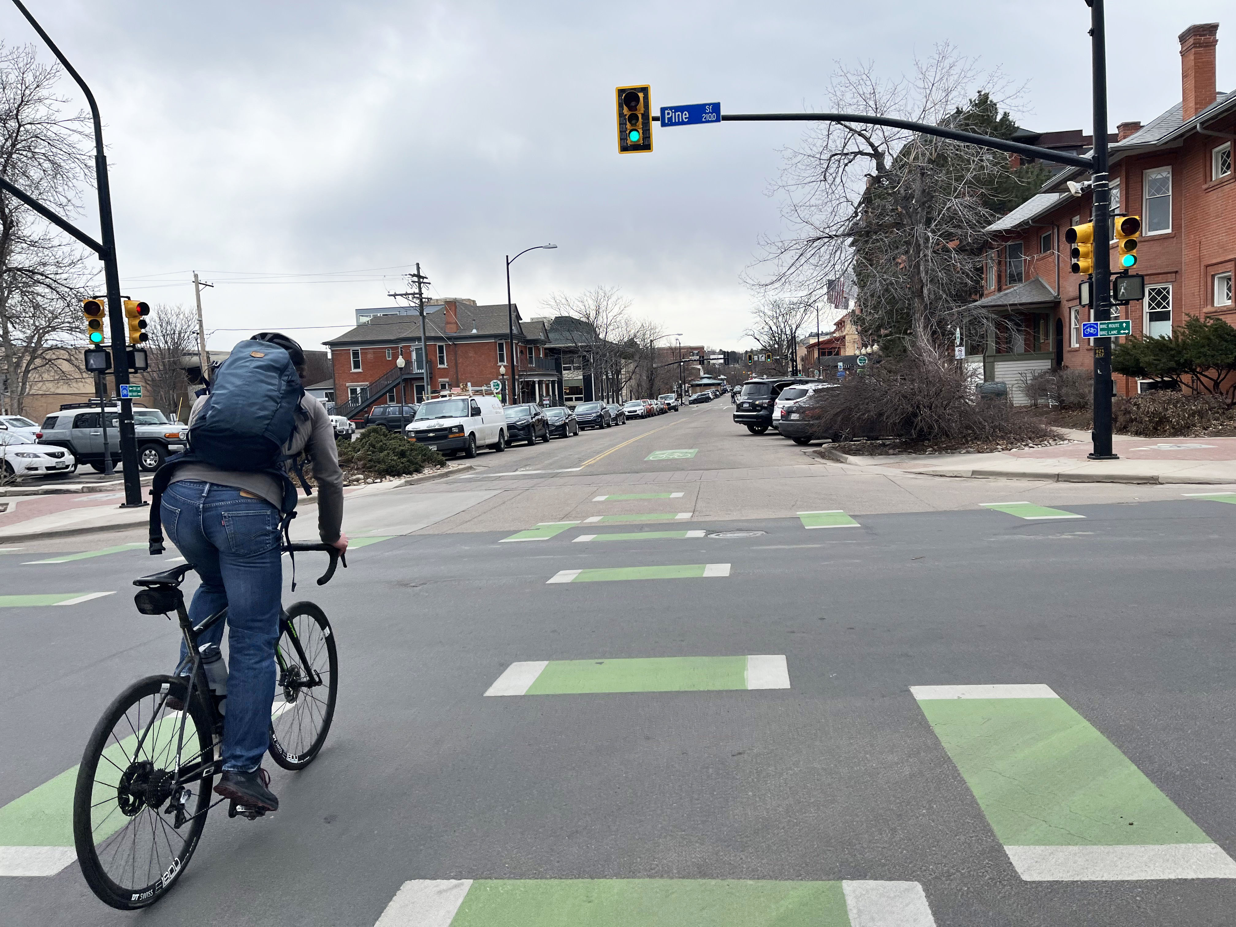 persona en bicicleta en las marcas verdes de carril bici en la intersección