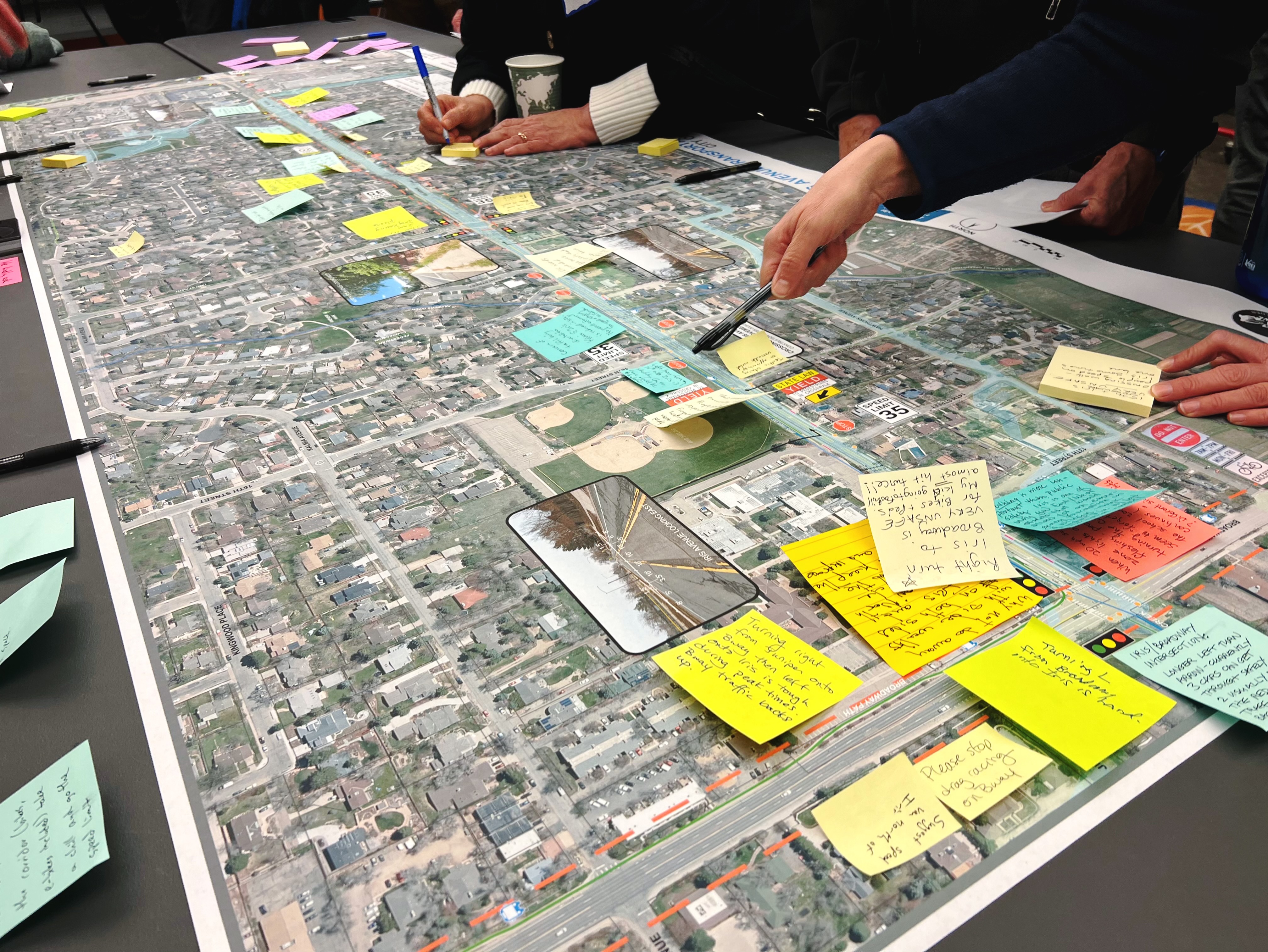 People writing down feedback and pointing to a map of Iris Avenue.