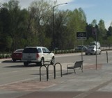 parada de autobús con banco al lado de la carretera y aparcamientos para bicicletas