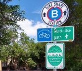 Señales de orientación para la estación de bicicletas compartidas y el camino de usos múltiples.