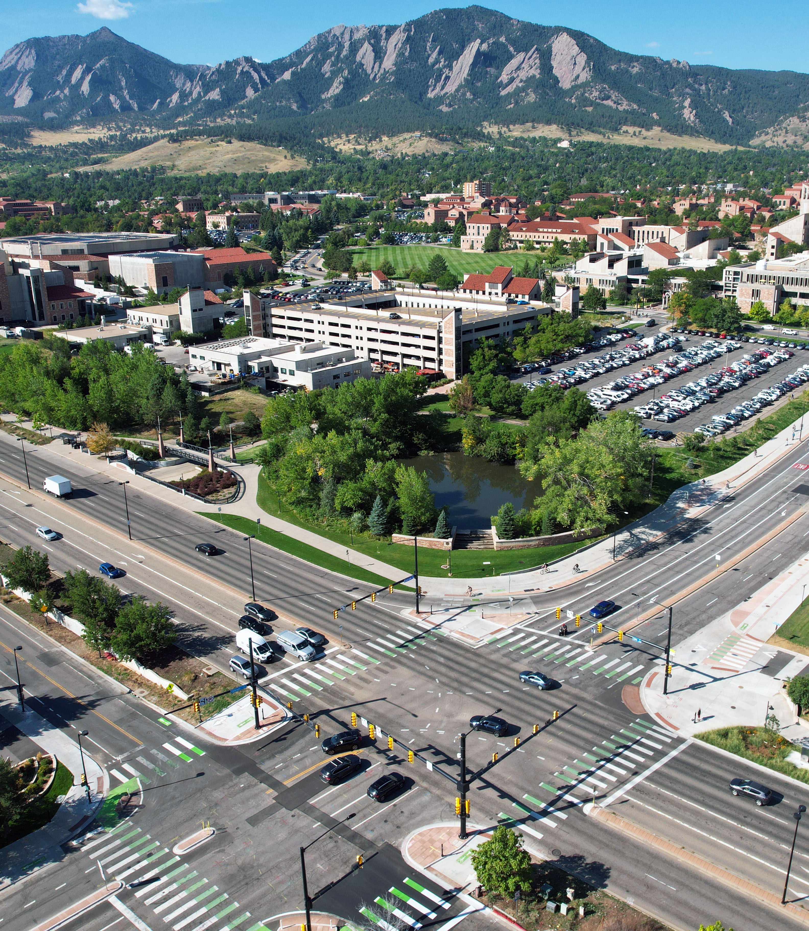 28th and Colorado intersection from above with the flatirons in the background. Buses, cars, bikes and people walking travel. 