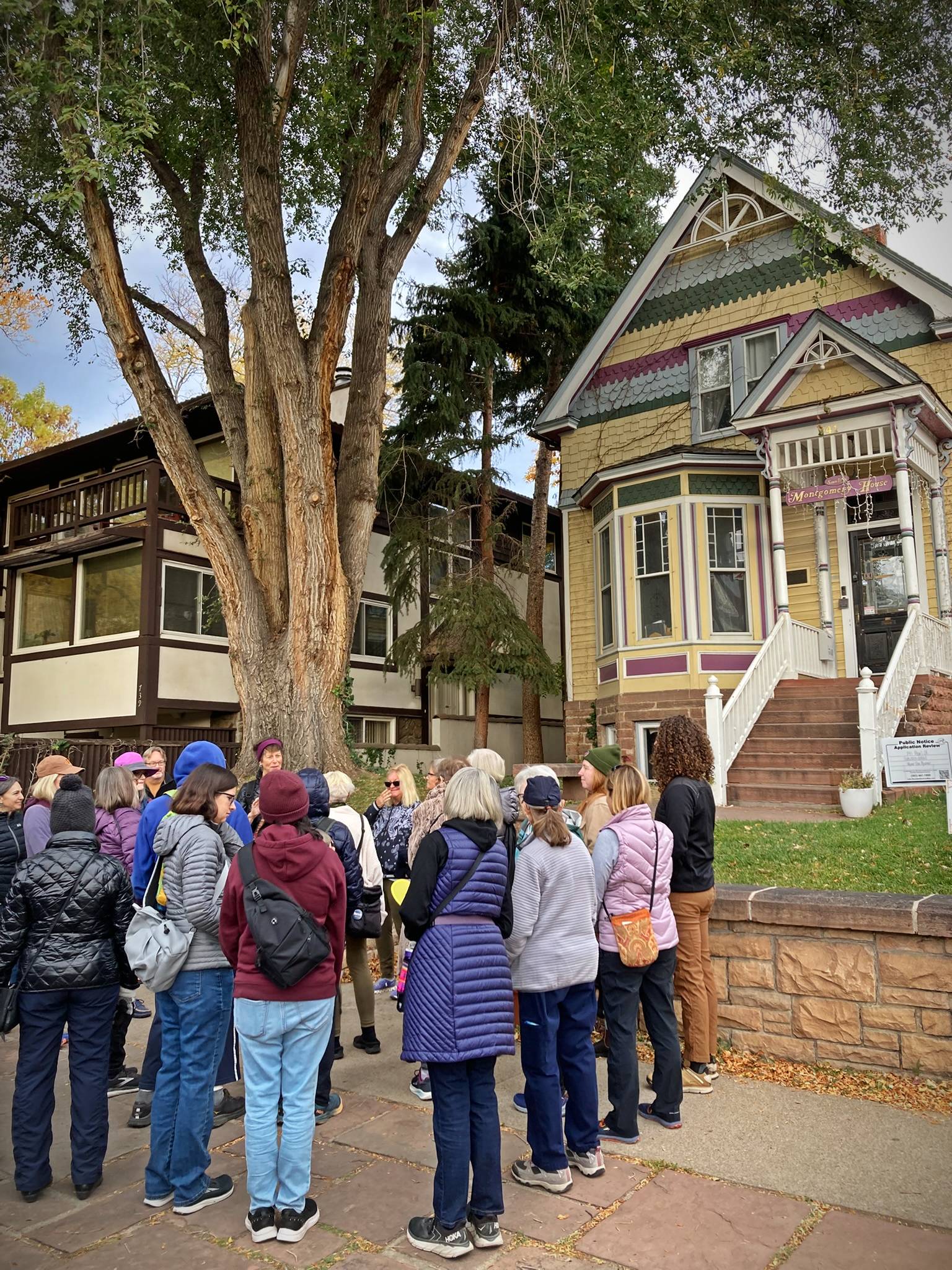 Group of adults gathered at a walking tour in front of a historic house downtown