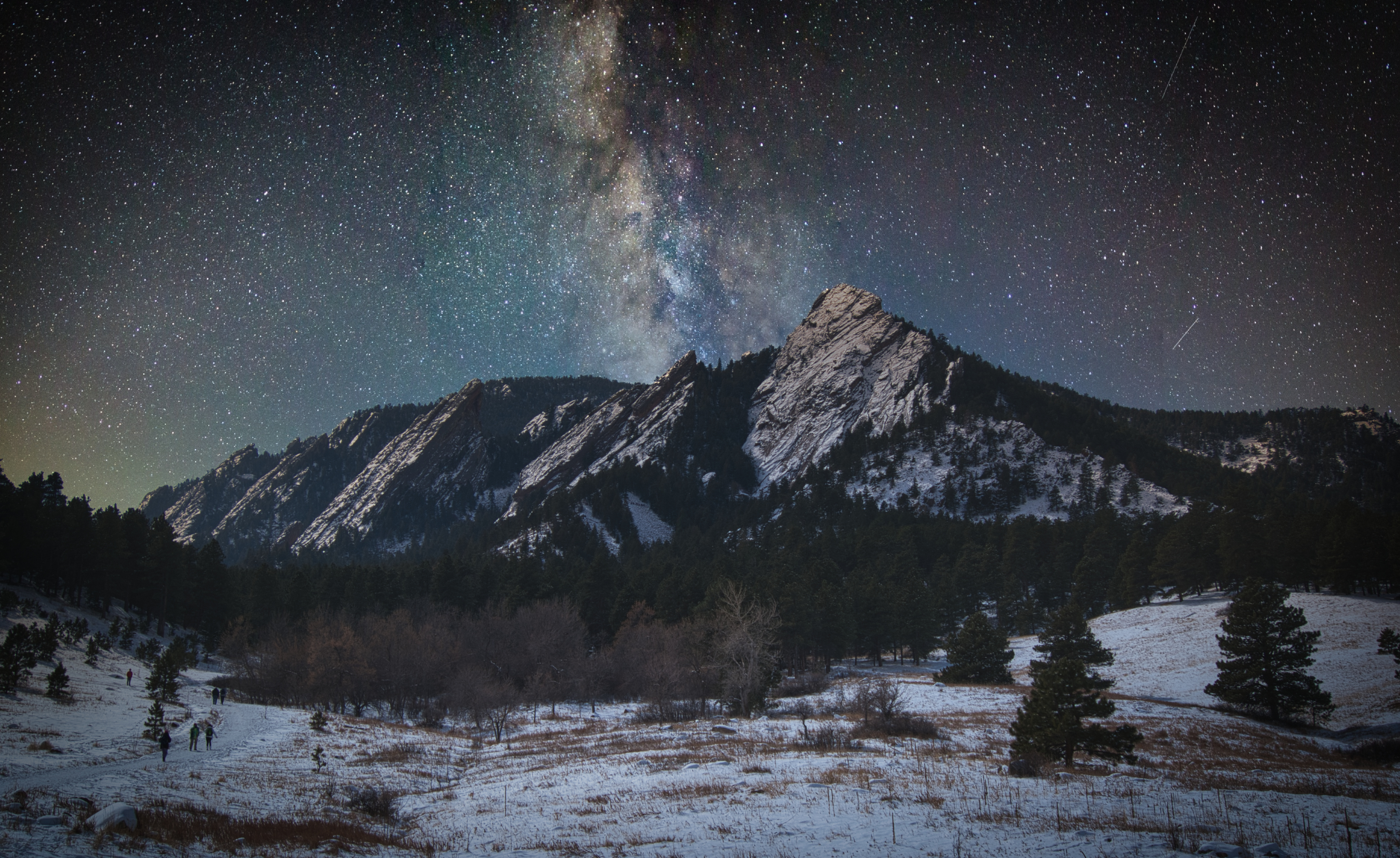 A starry night winter scene above the Flatirons in Boulder