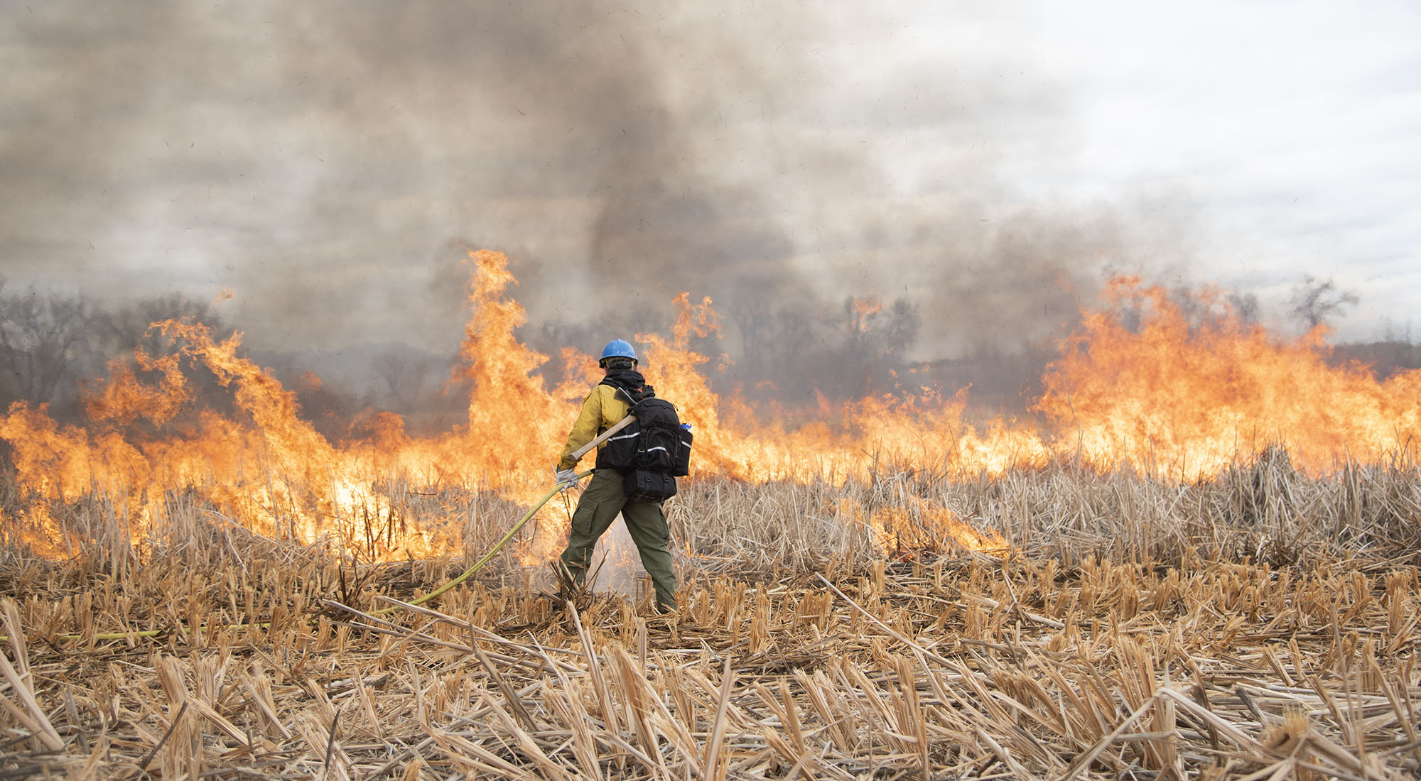 A firefighter monitors a prescribed burn east of Boulder