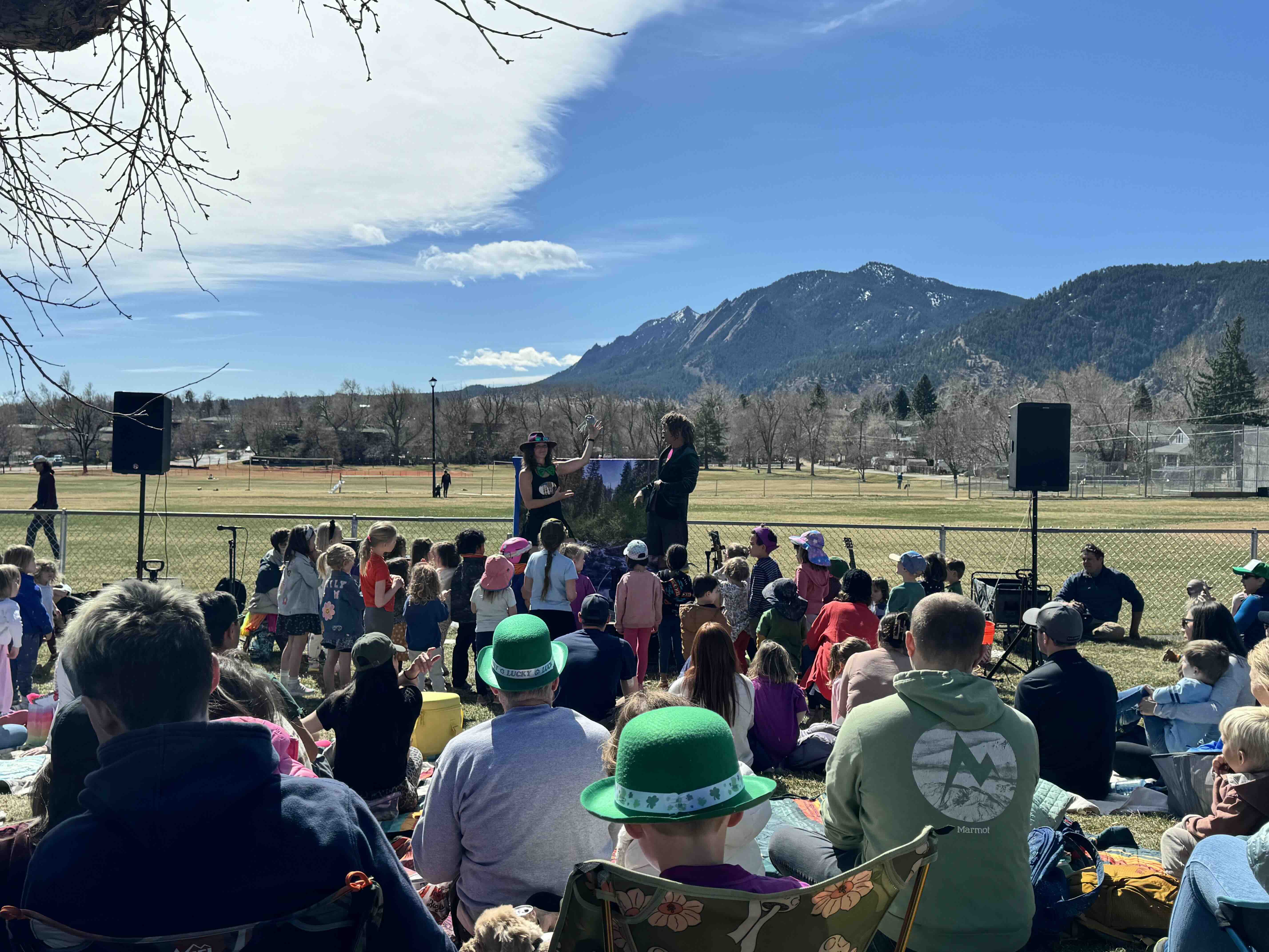Jeff and Paige performing a concert for youth on a sunny Sunday in North Boulder Park with the Flatirons in the background.