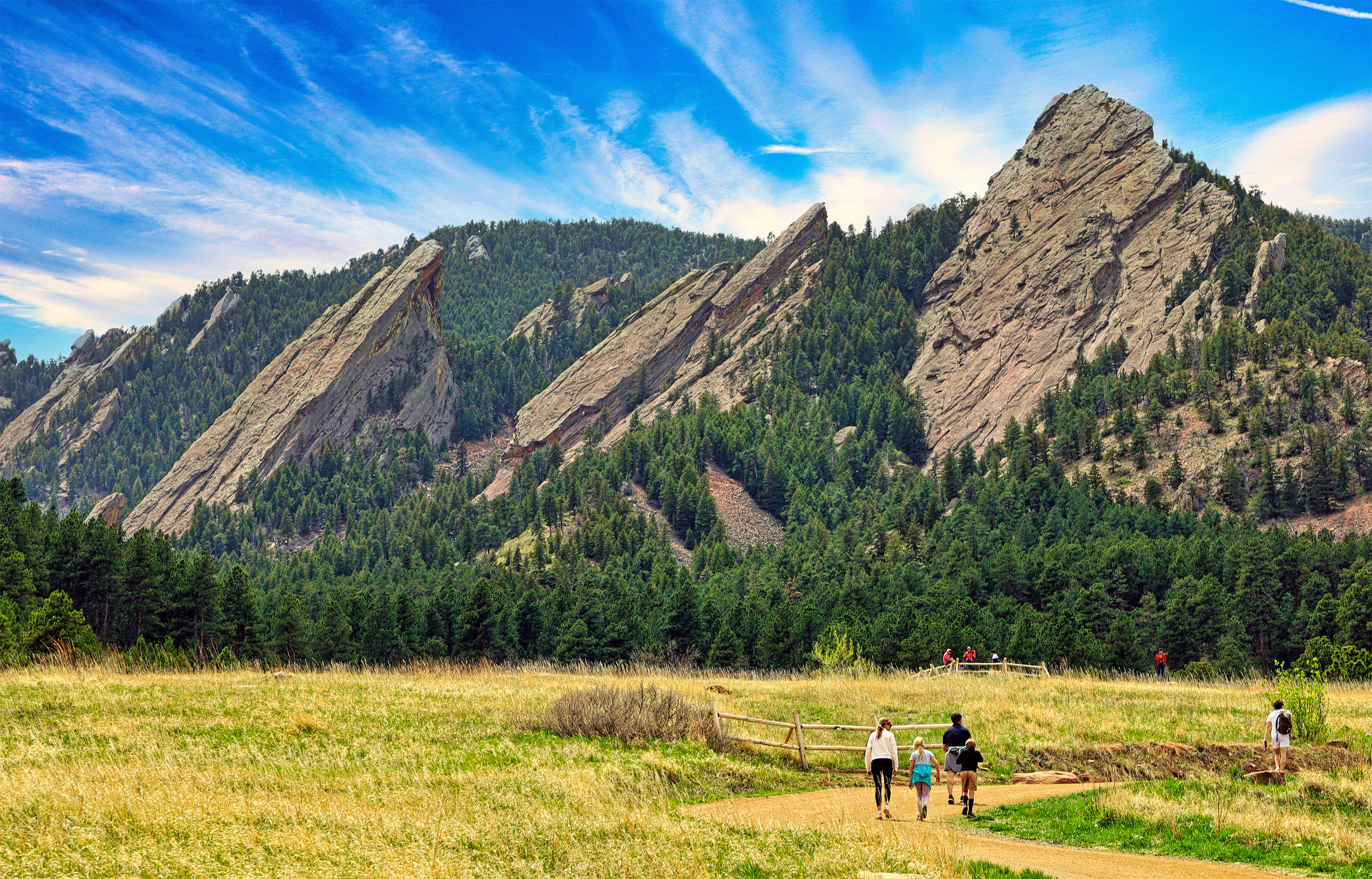 Chautauqua hike with view of flatirons and family walking up