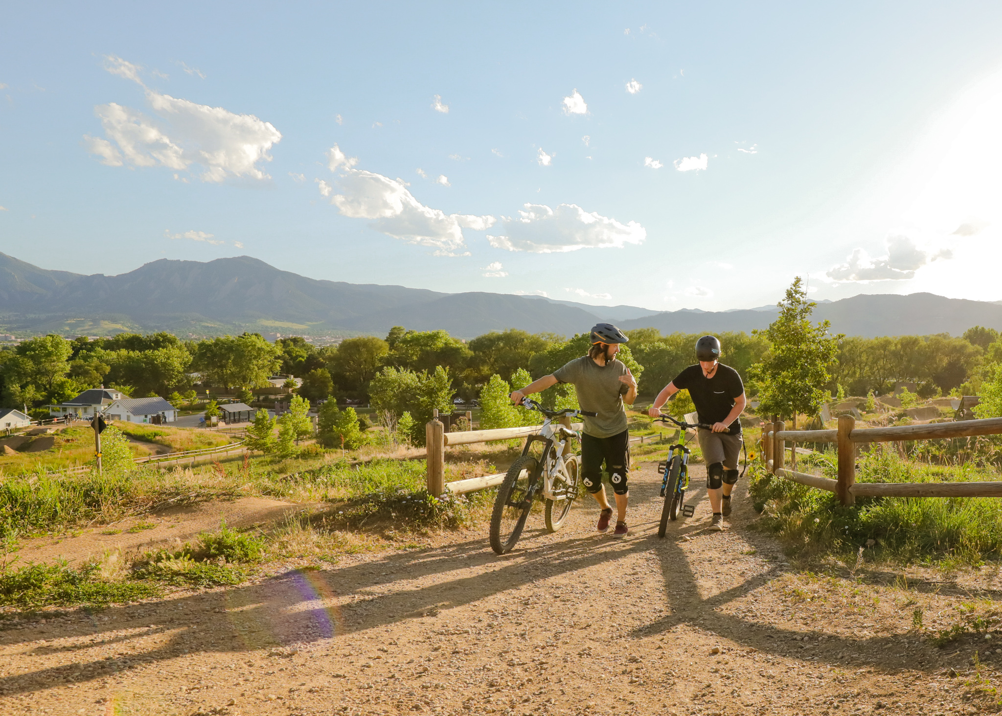 People walking with bikes at Valmont Bike Park dirt trail