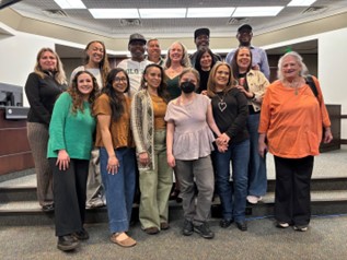 Group of smiley people standing in council chambers room