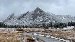 Chautauqua Trail with The Flatirons in the background, all covered in light snow.