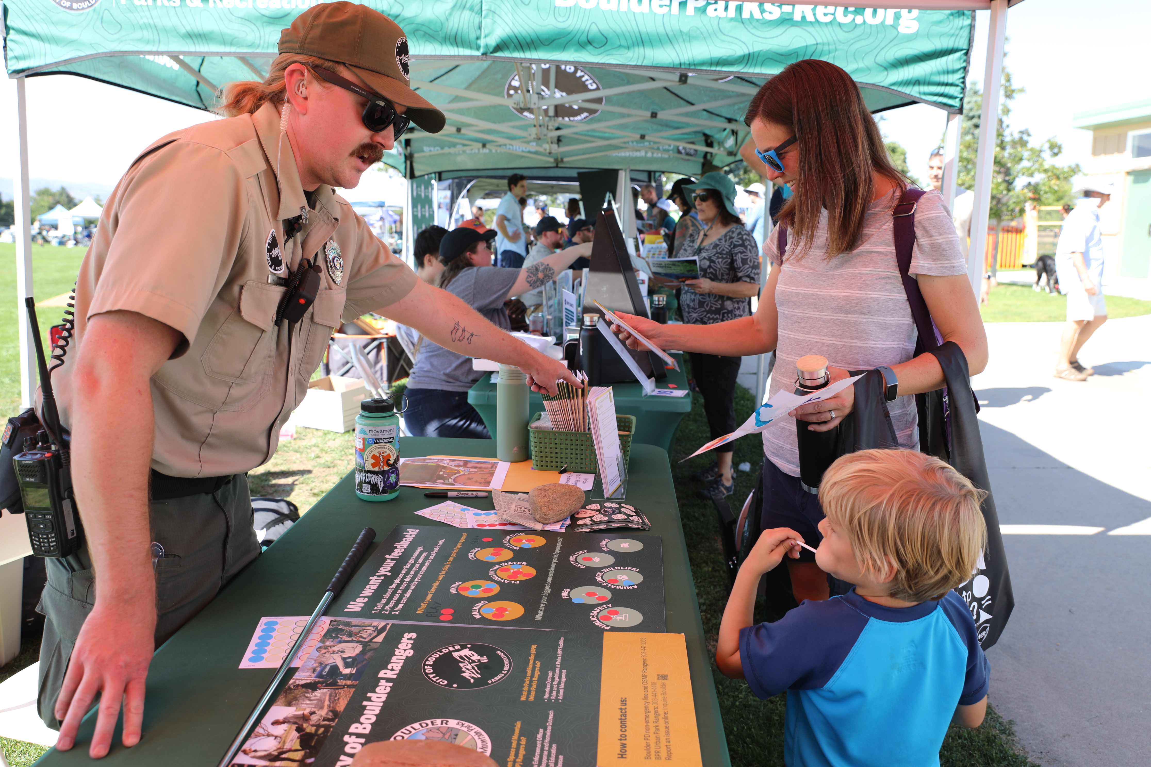 Urban Ranger talking to a family at What's Up Boulder event
