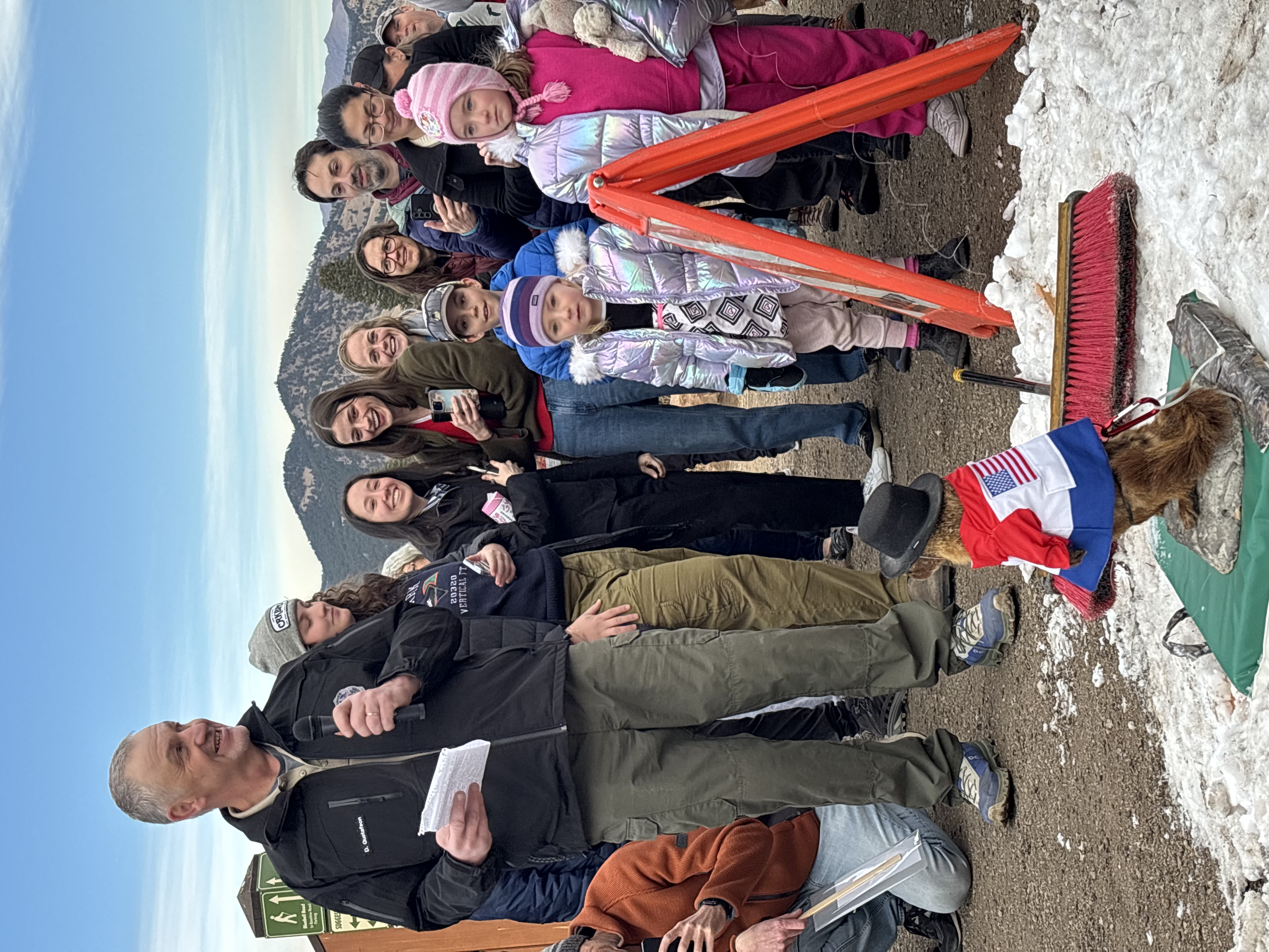 Ranger man standing in front of a crowd of people smiling while he reads a script.