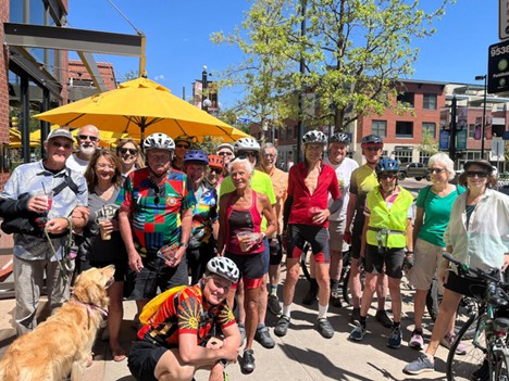 Group of older adults posing for a photo on Pearl Street during a biking event. 