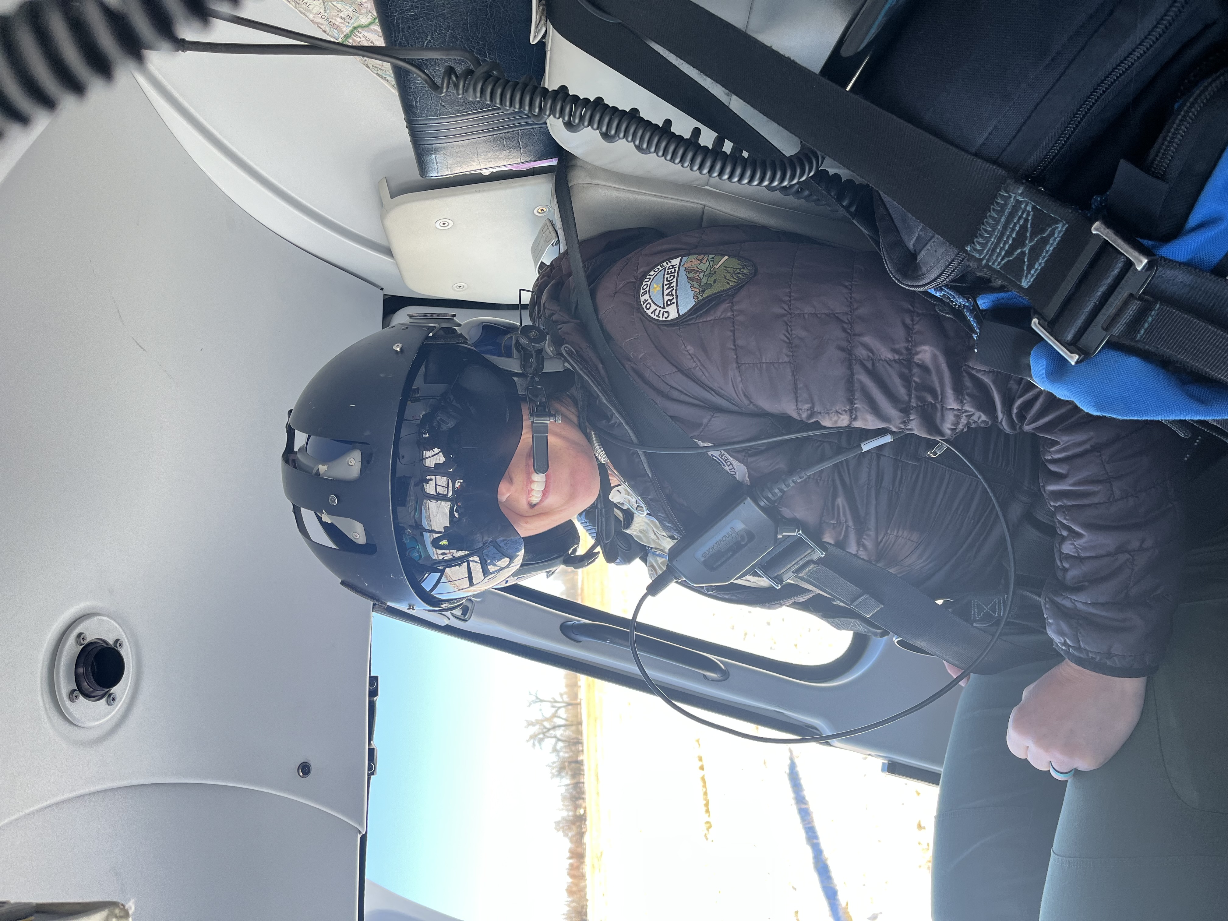 Ranger in helicopter with helmet on.
