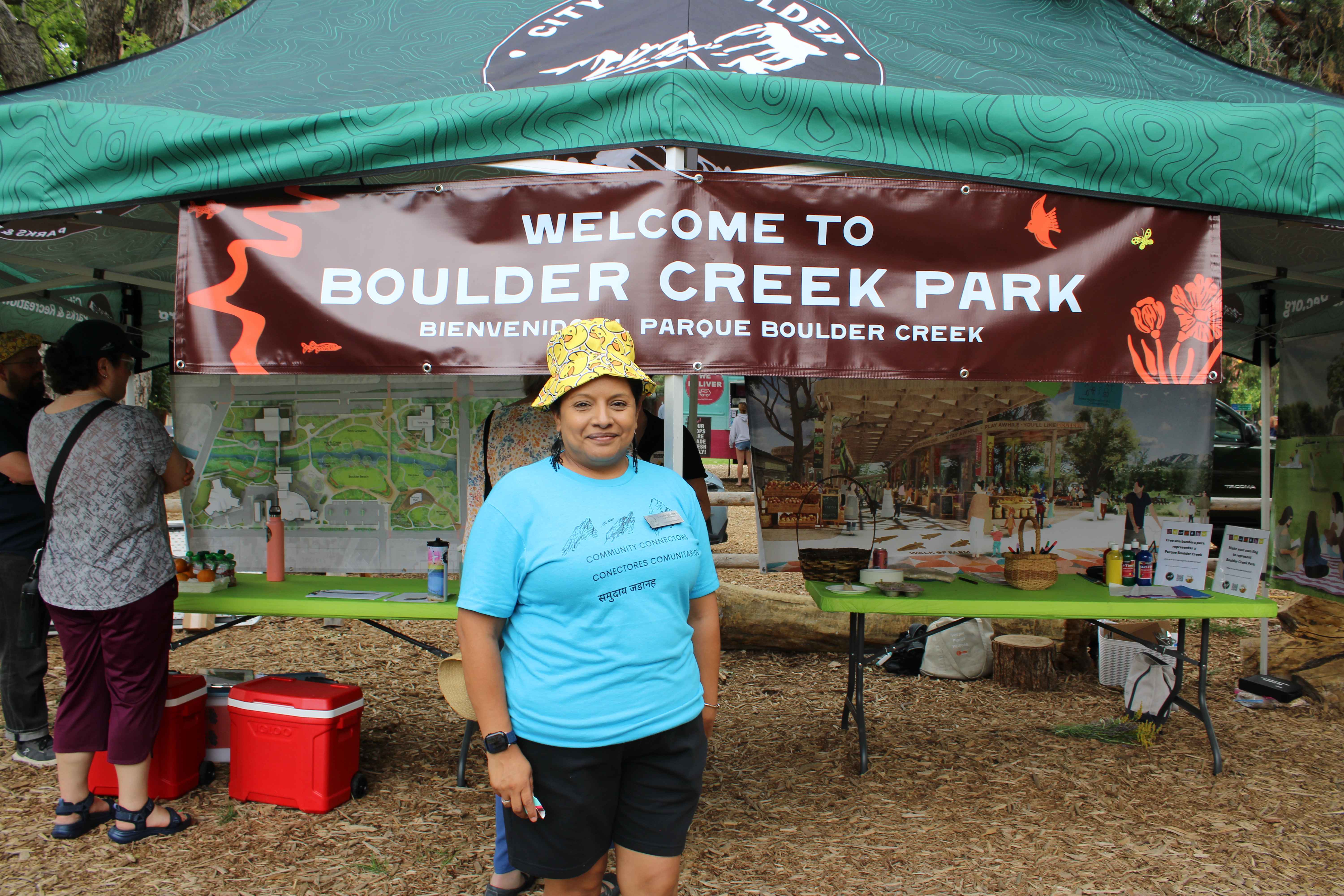 Claudia in front of Boulder Creek Park banner