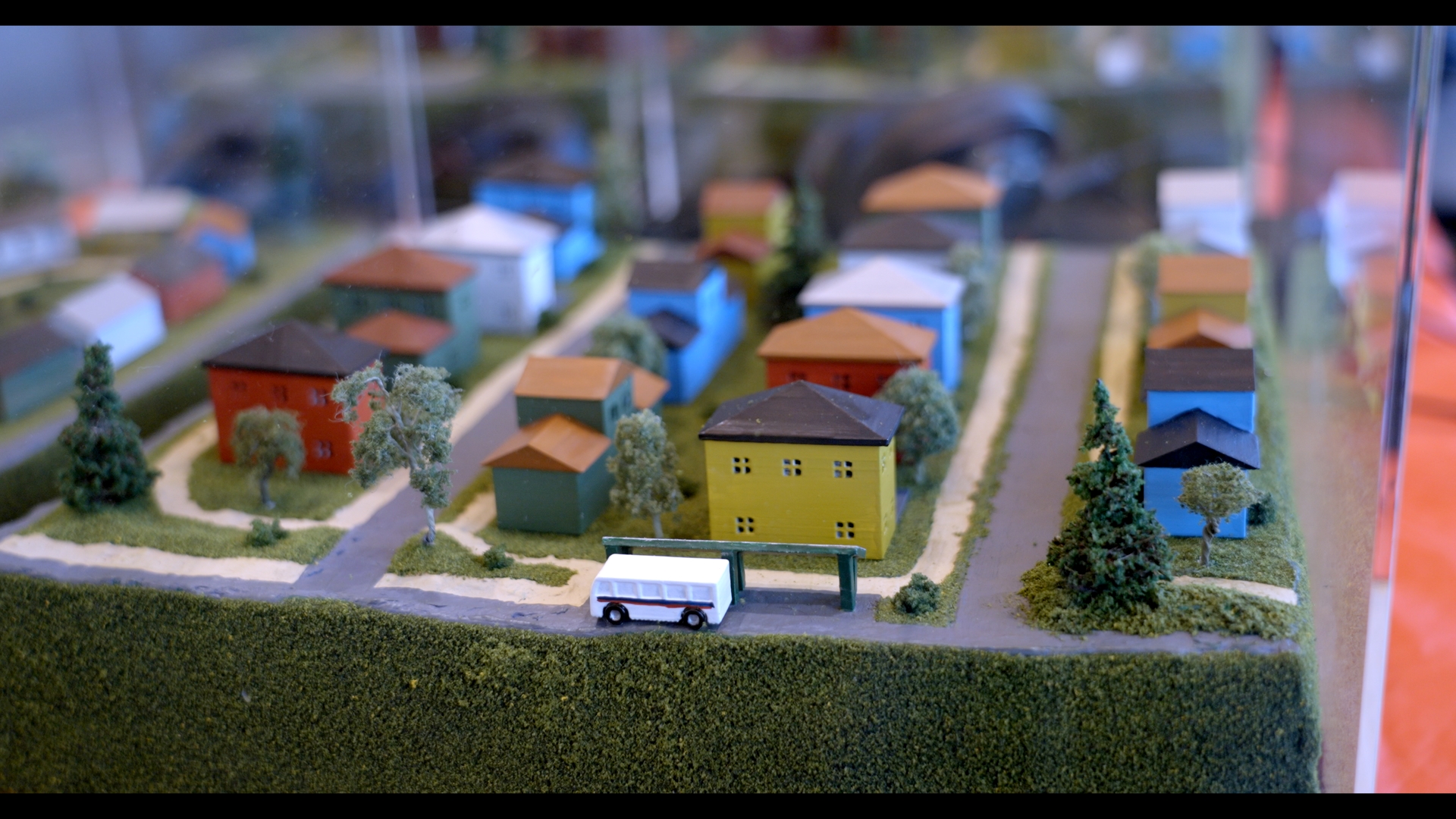 Model street with bus parked next to a building
