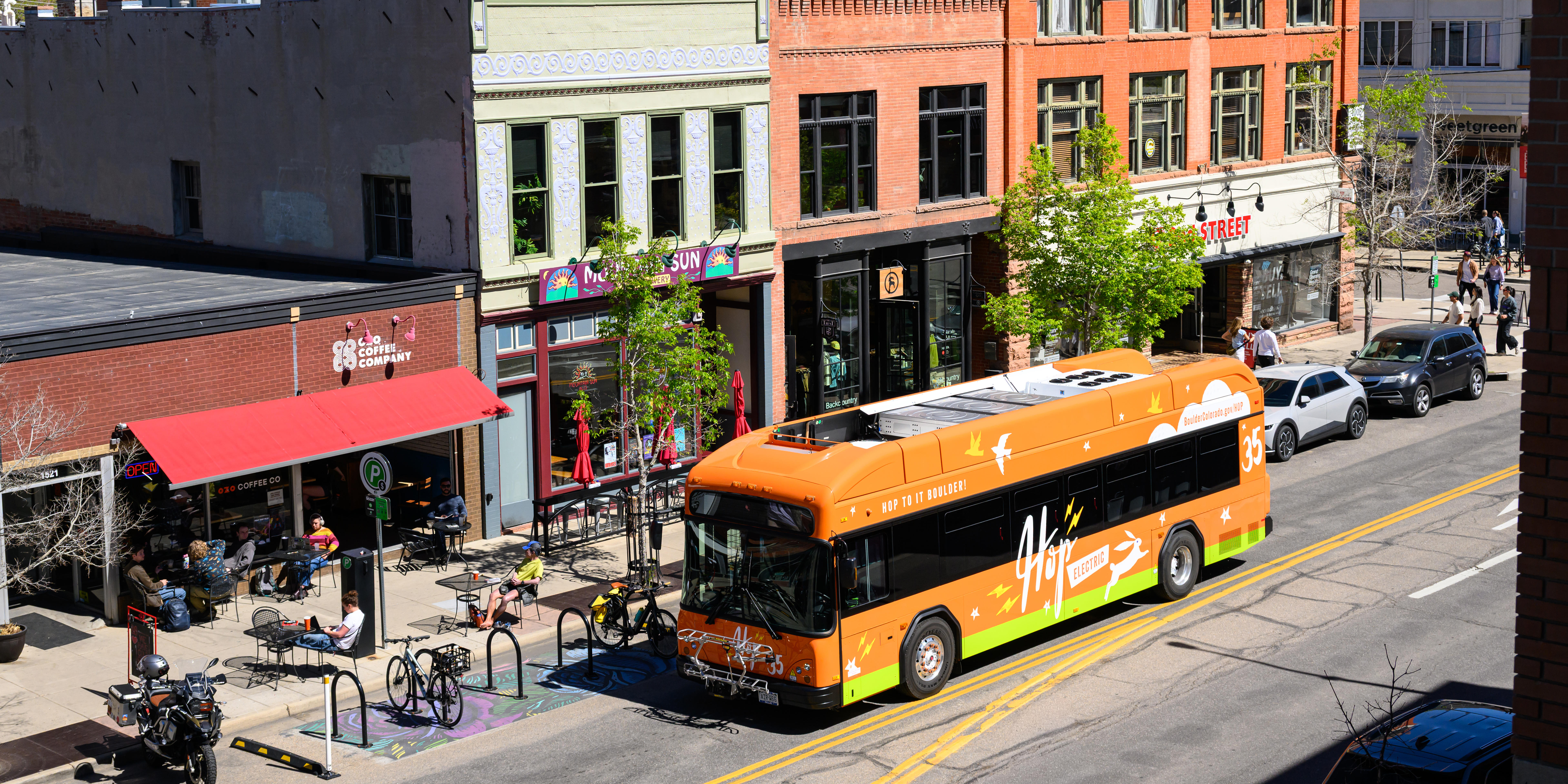 Bus driving by bicycles parked at a bike rack.
