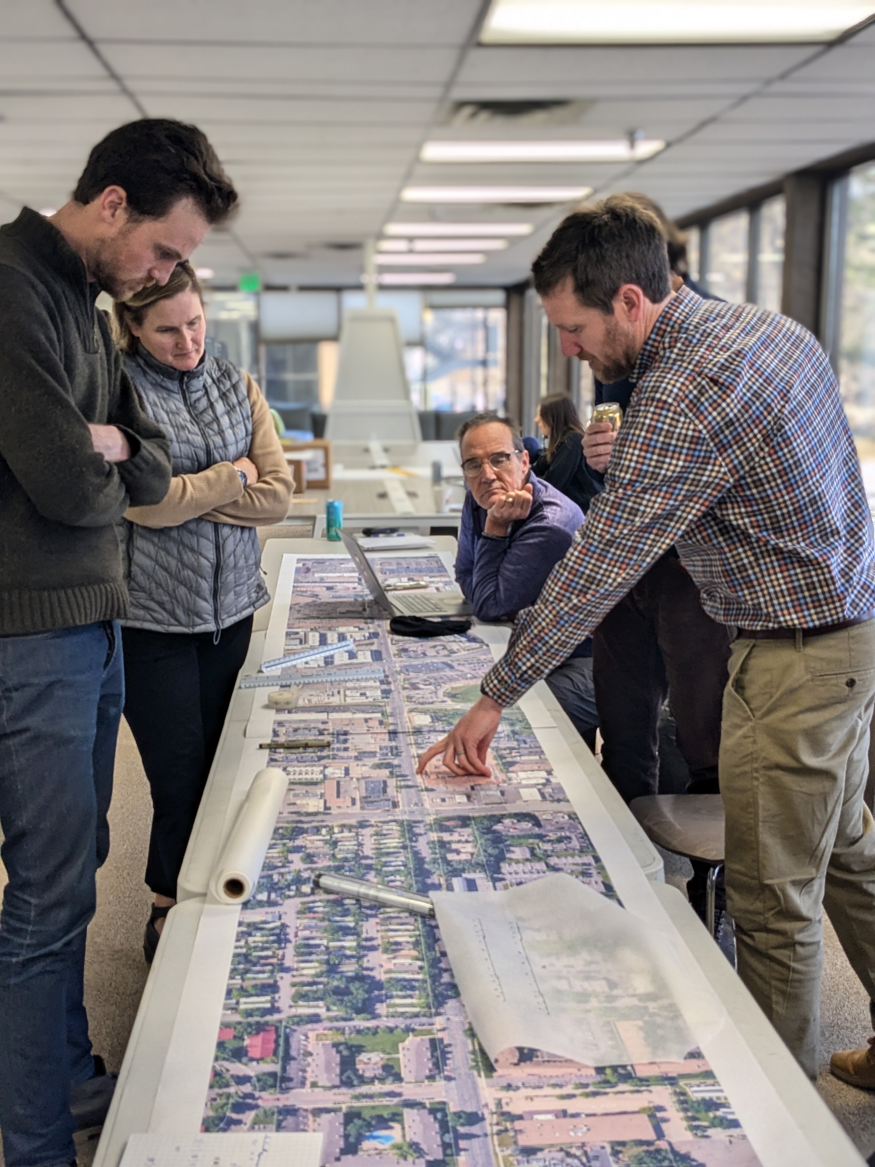 Four people looking at a map of 30th Street. 
