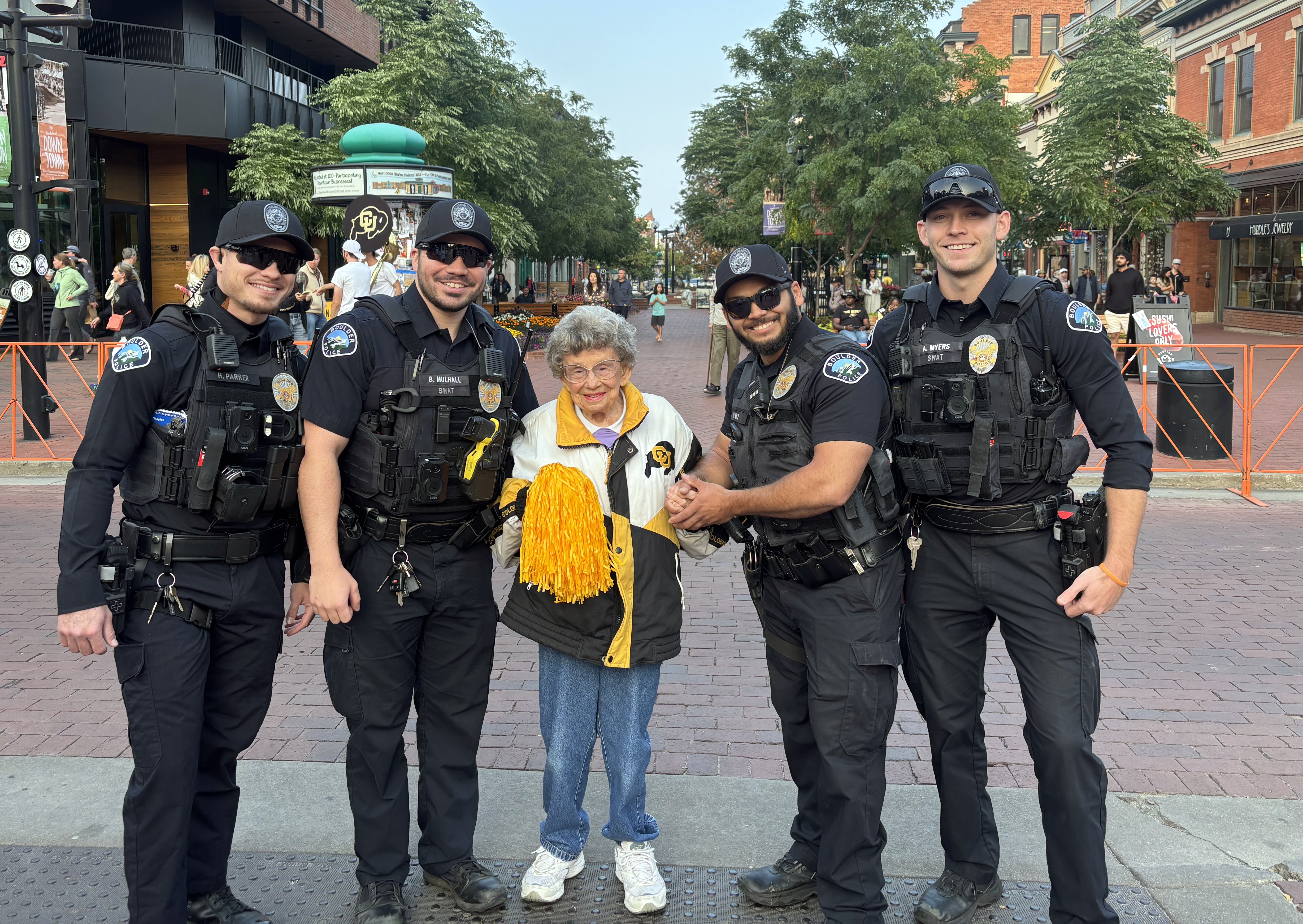 image of Boulder police officers with longtime CU Boulder legacy Miss Peggy