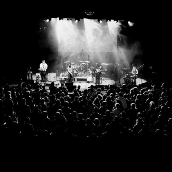 Band performing on stage to large audience