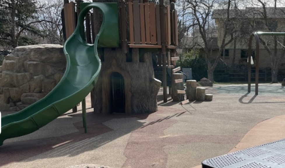 fort like play structure with slide and rocks