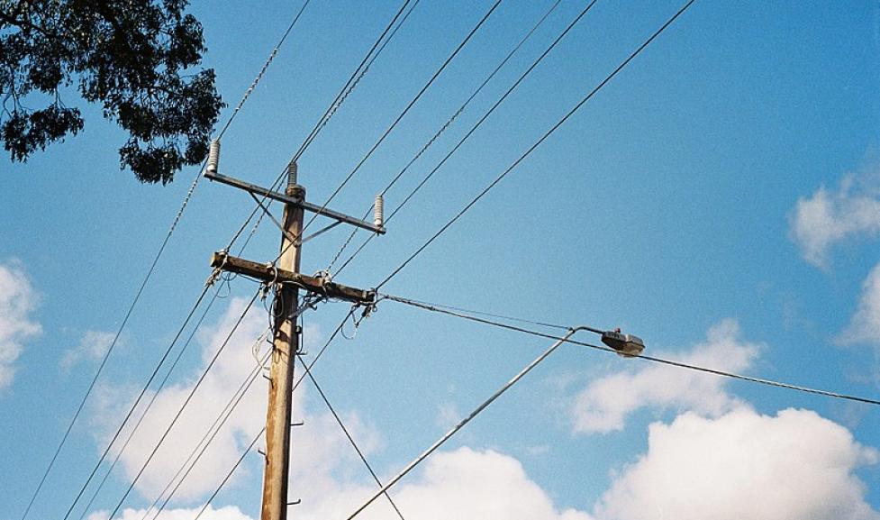 A distribution power line pole holds up several wires