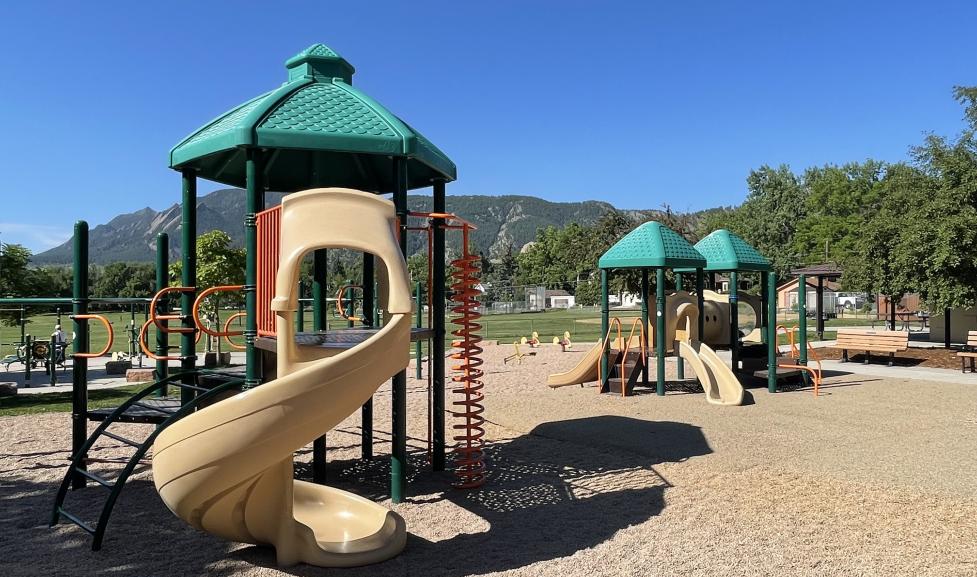 Existing playground structures with slides at North Boulder Park. Mountains in the background