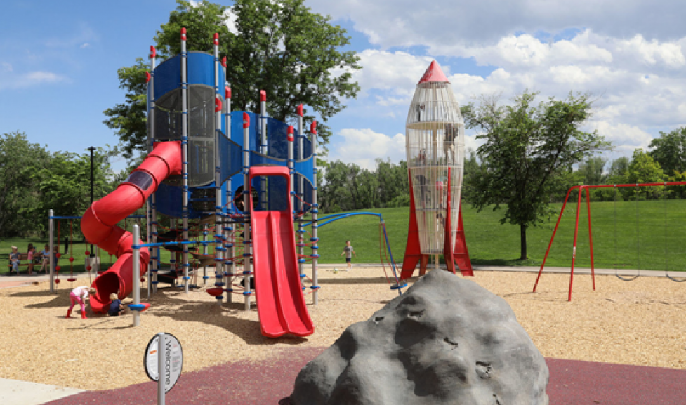 Climbing and slide structure, with a rock in the play area and the spaceship