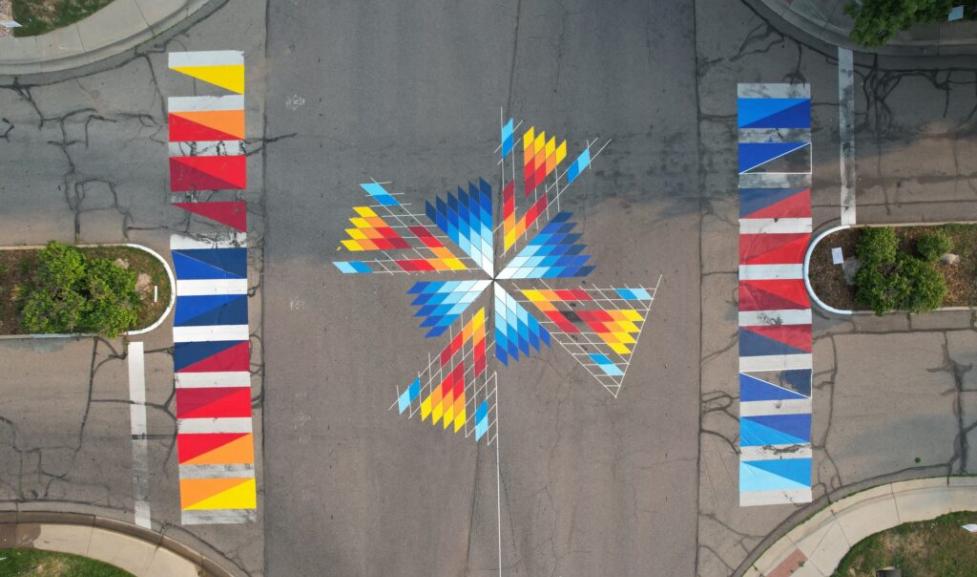 Aerial shot of a colorful mural on the street in the middle of an interseciton