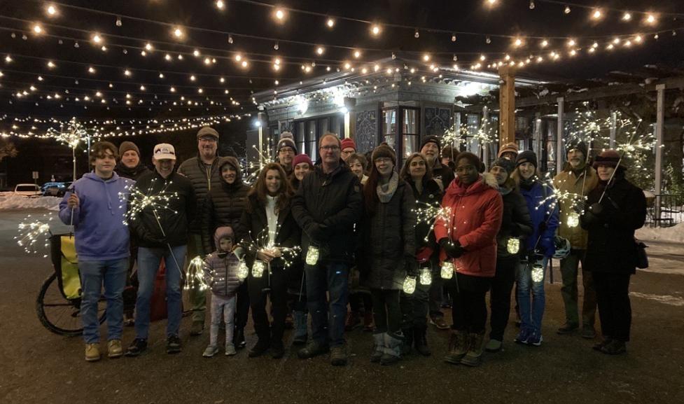 People gathered with lights downtown on a memorial walk for traffic victims