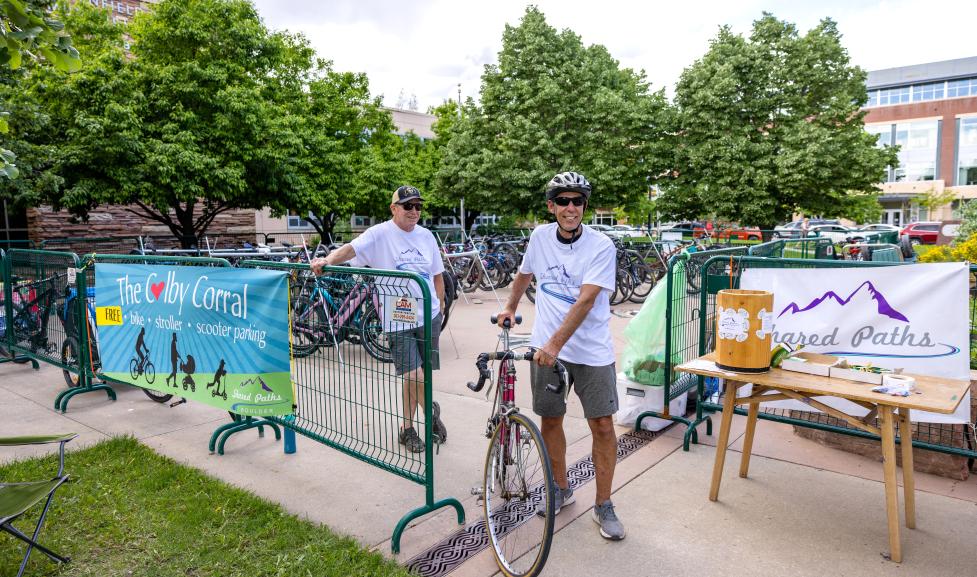 A bicyclist parking their bike in secure storage at a downtown event