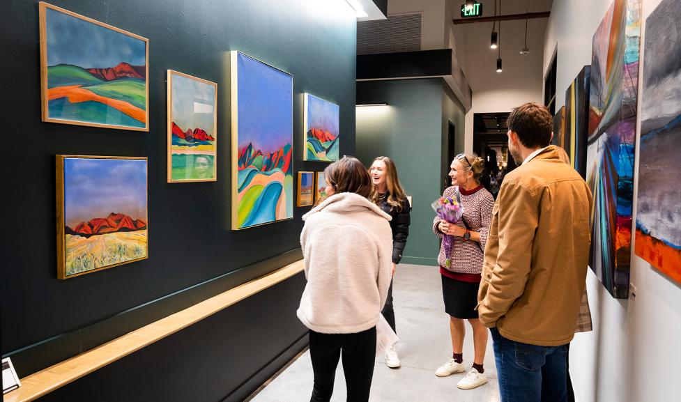 Attendees of an art exhibit looking at paintings