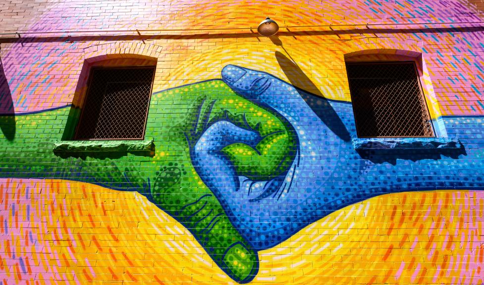 Mural of blue and green hands holding