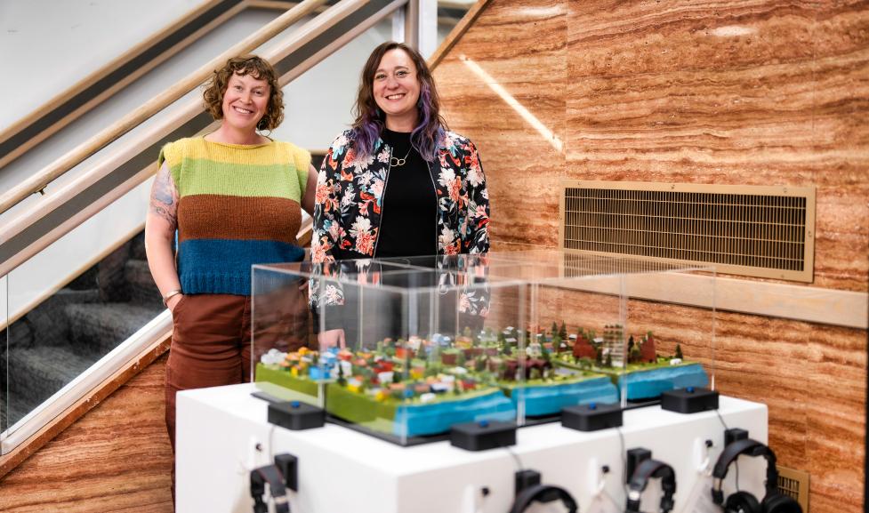Artists standing behind their project in the Penfield Tate Municipal Building lobby