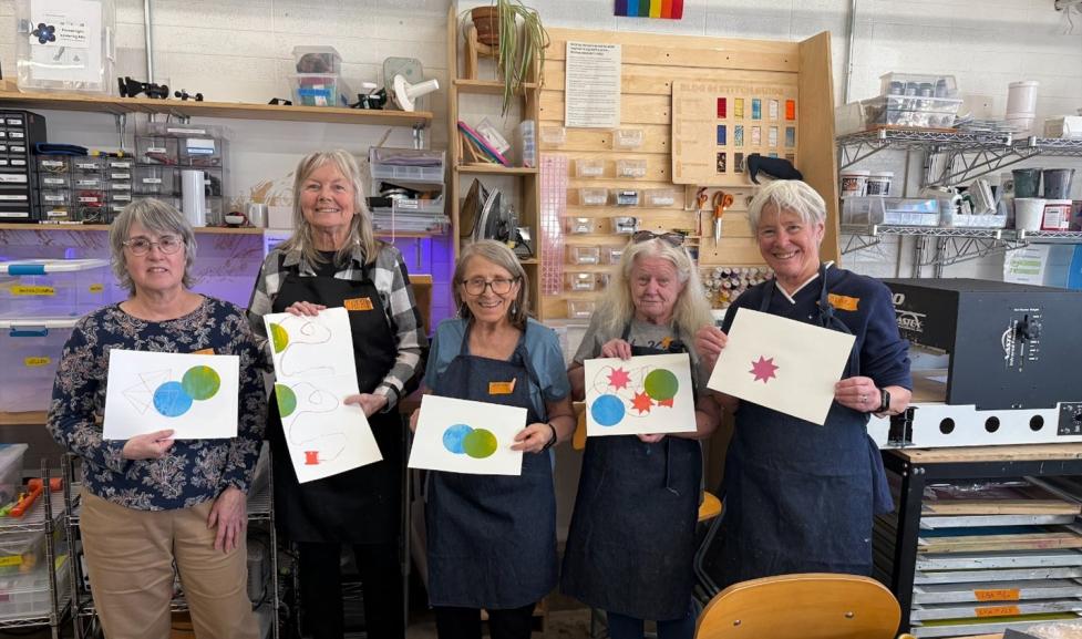 Five older adult women showing off their artwork made in the city's Makerspace. 