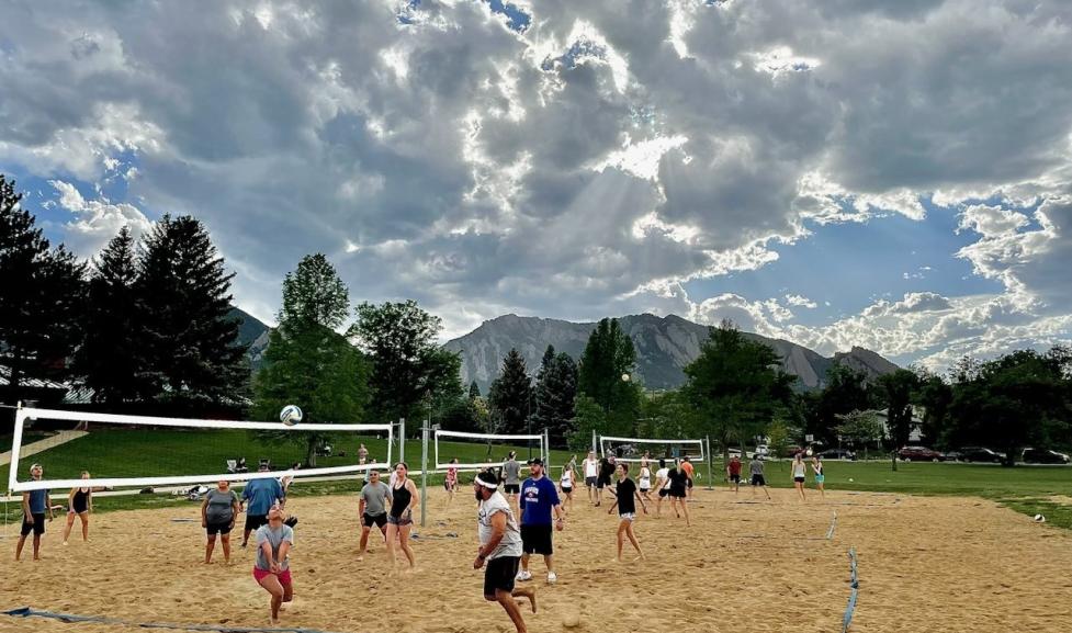 Volleyball teams playing on sand courts with mountains in the background