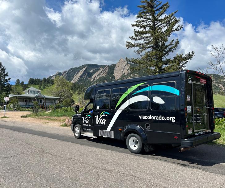 park-to-park shuttle, black with via logo, in front of flatirons